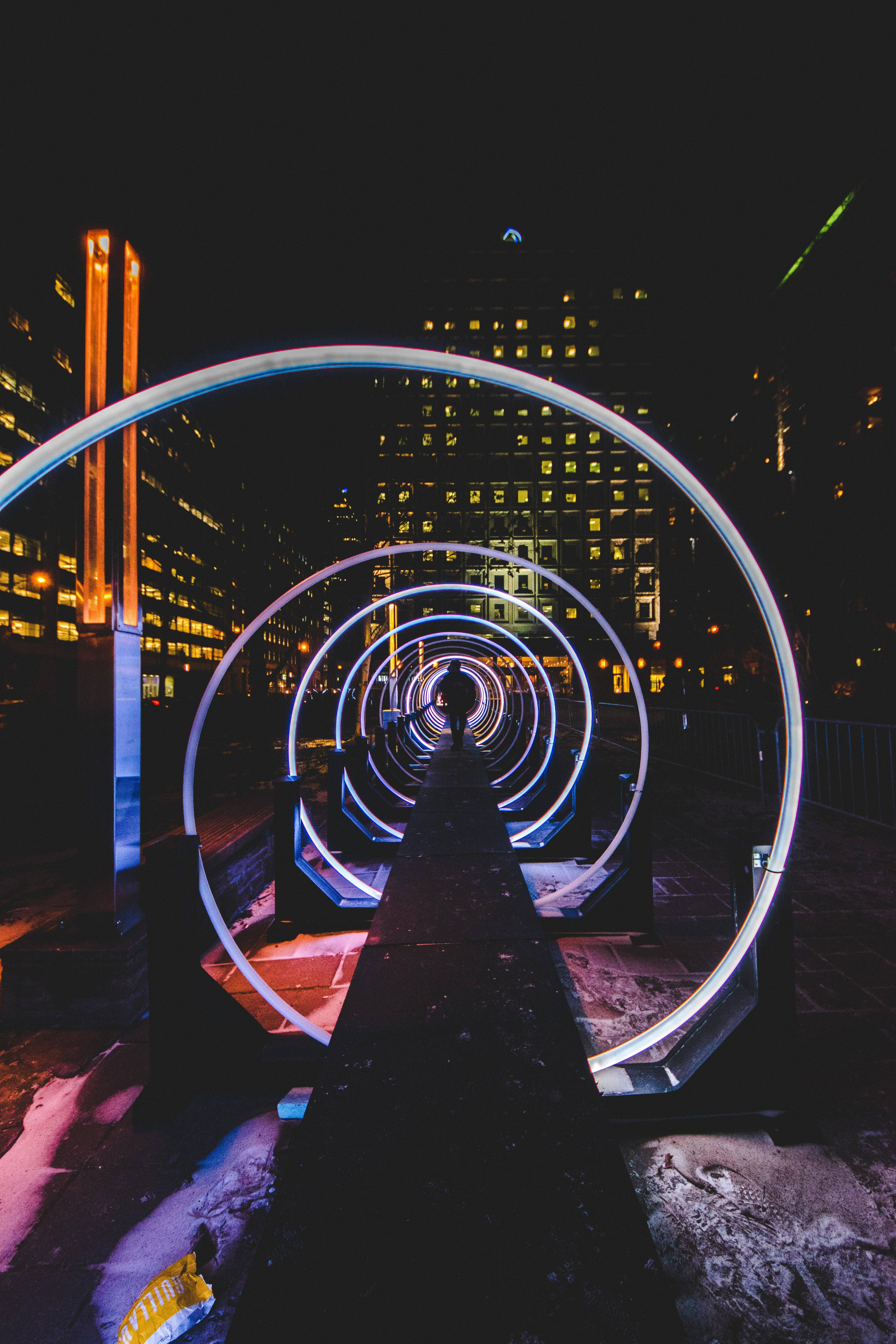 Spiral Led Road, glowing neon rings, snowy urban setting, 5K Phone Wallpaper