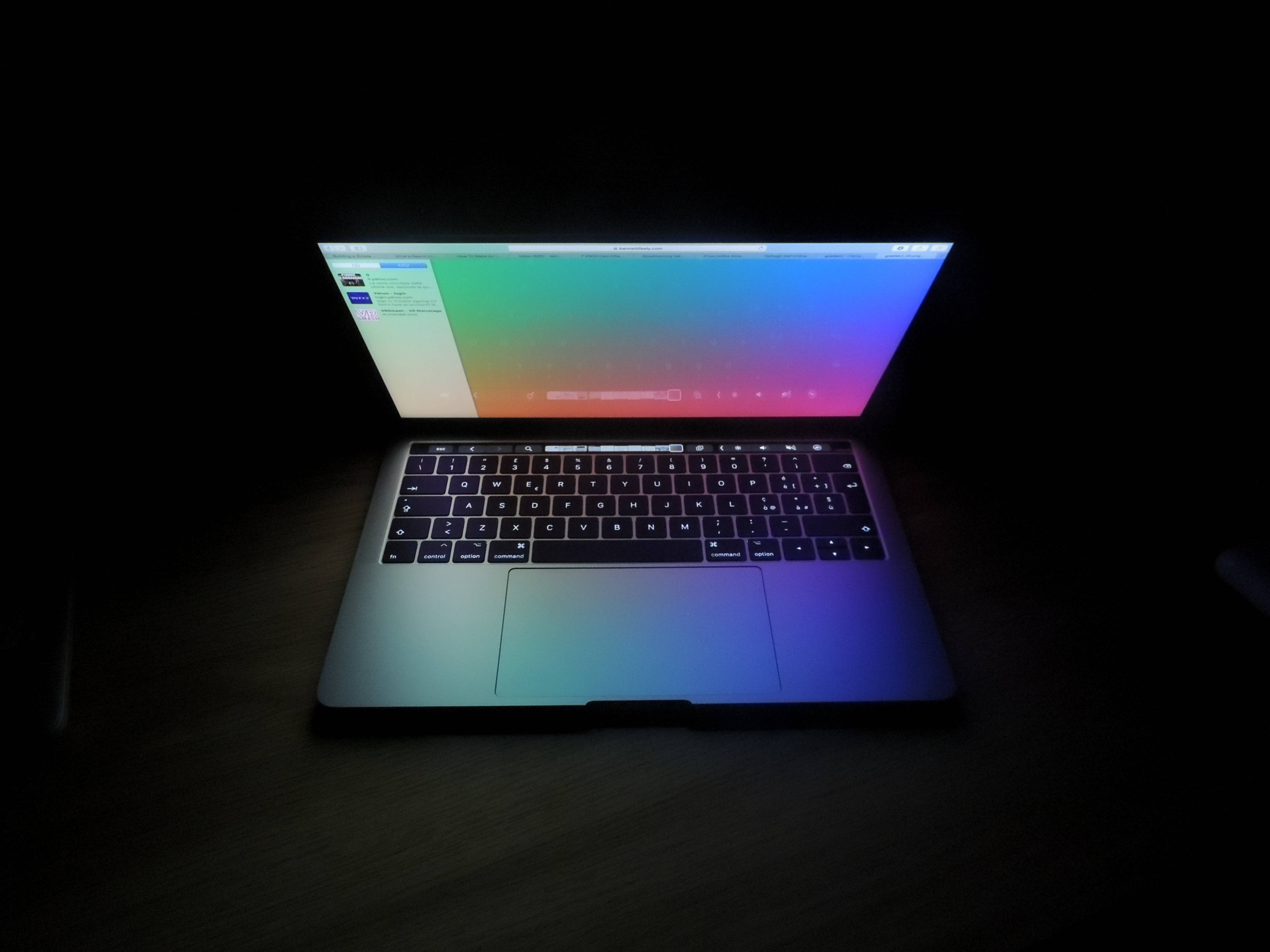 laptop, vibrant gradient screen, dark wooden desk, 4K Desktop Wallpaper