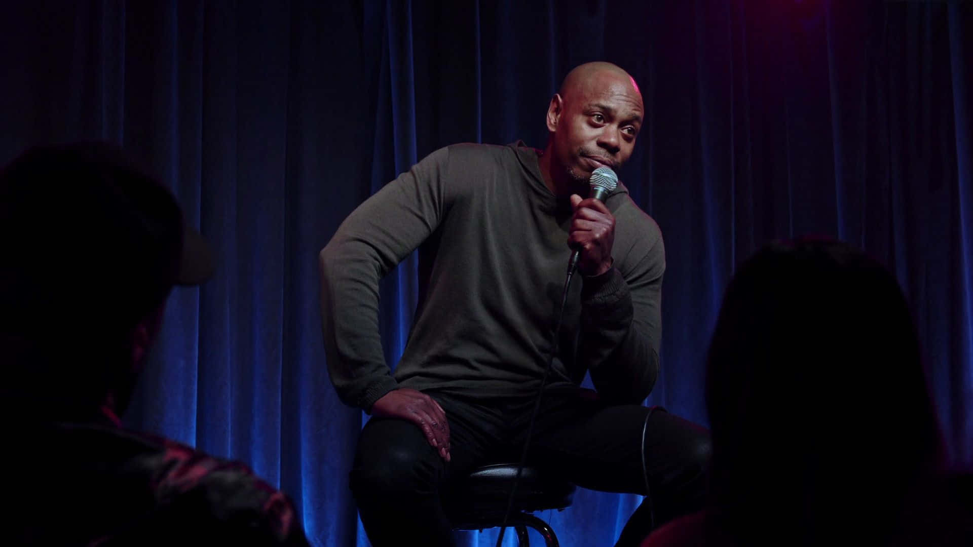 Dave Chappelle, dark hoodie, dimly lit stage, Full HD Desktop Wallpaper
