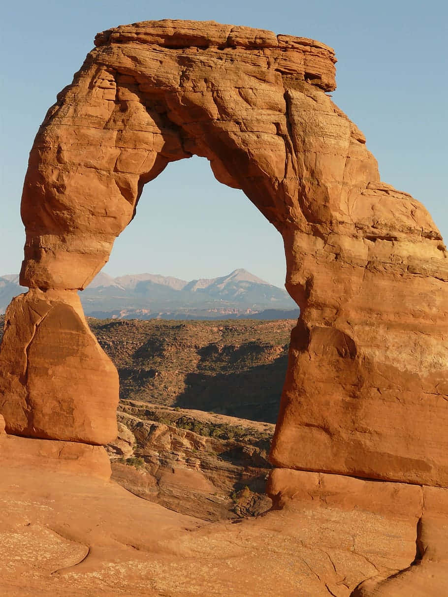 Delicate Arch, red sandstone arch, snow-capped mountains, SD Phone Wallpaper