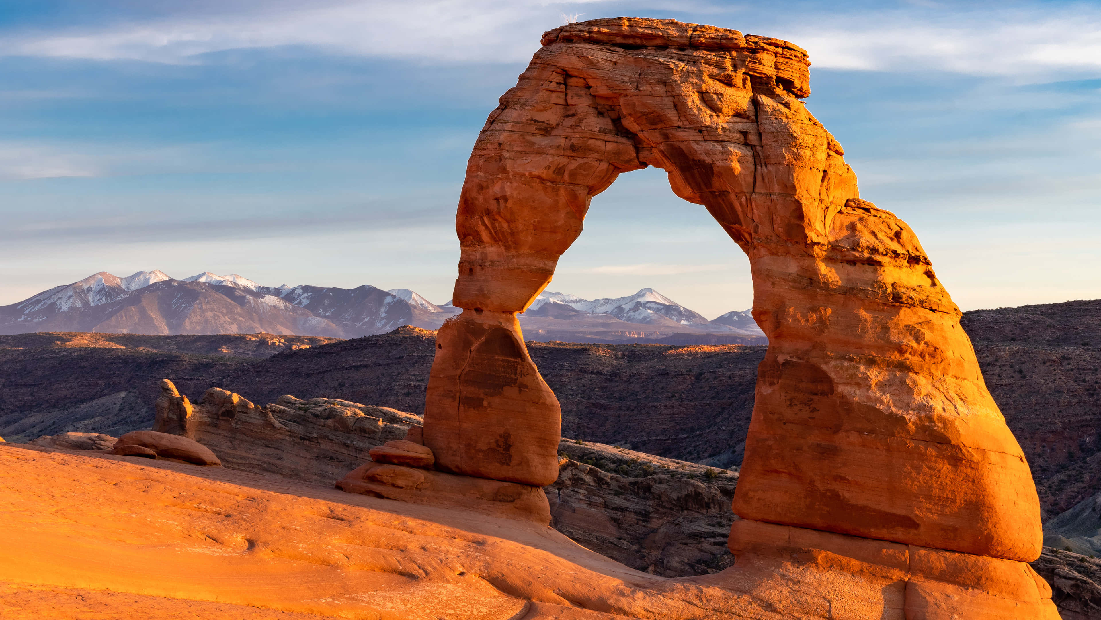 Delicate Arch, orange sandstone arch, snow-capped mountains, 4K Desktop Wallpaper