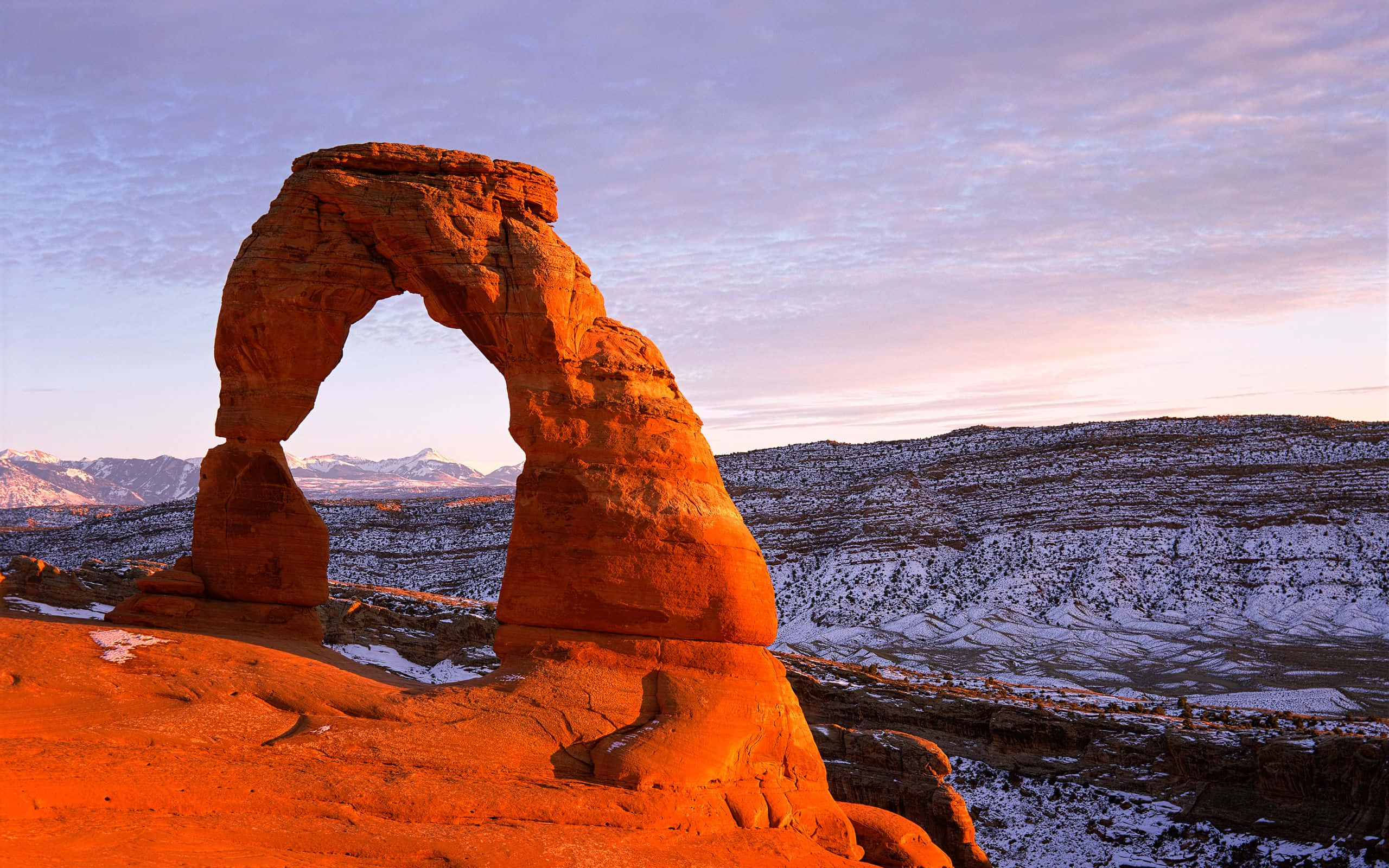 Delicate Arch, orange sandstone arch, snowy desert landscape, 2K Desktop Wallpaper
