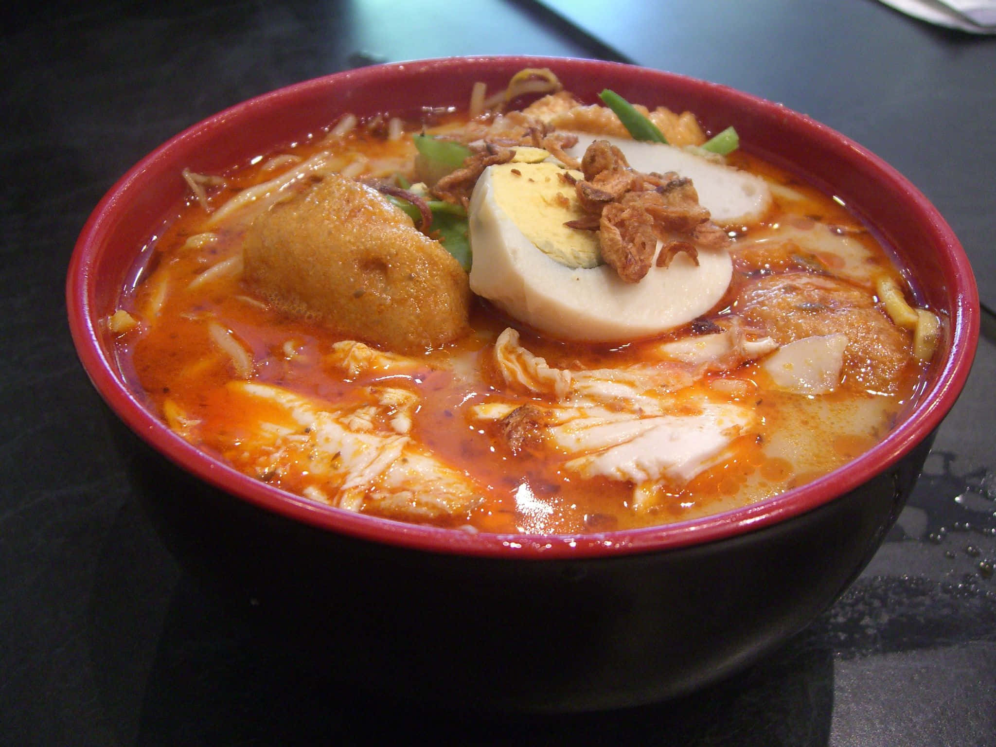 Singaporean coconut curry laksa, steaming bowl, rich red noodle soup, Full HD Desktop Wallpaper