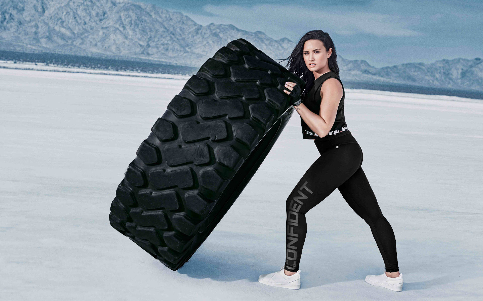 Demi Lovato, black athletic wear, massive black tire, Full HD Desktop Wallpaper