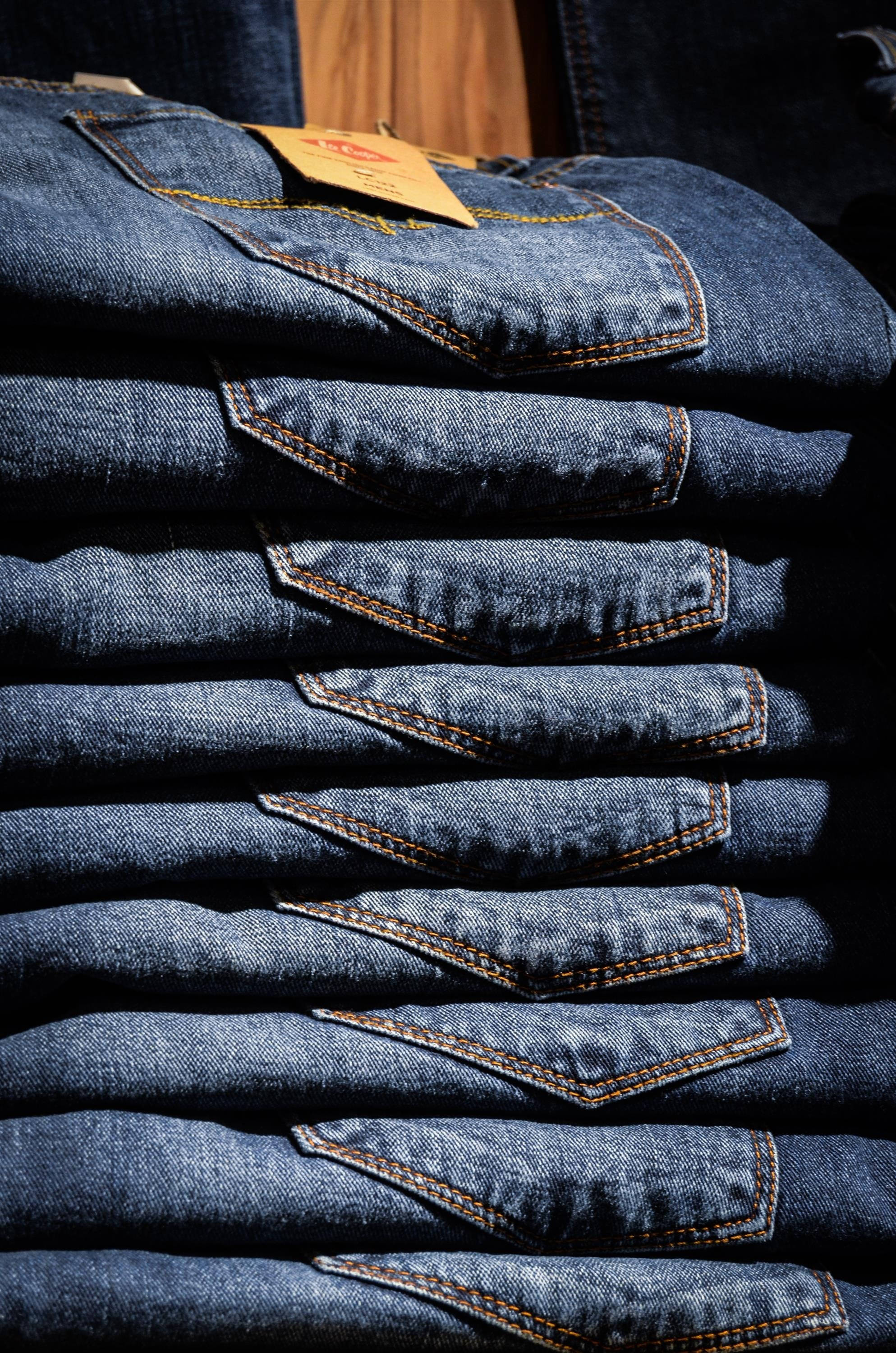 stacked blue denim jeans, orange stitching, tags, 2K Phone Wallpaper
