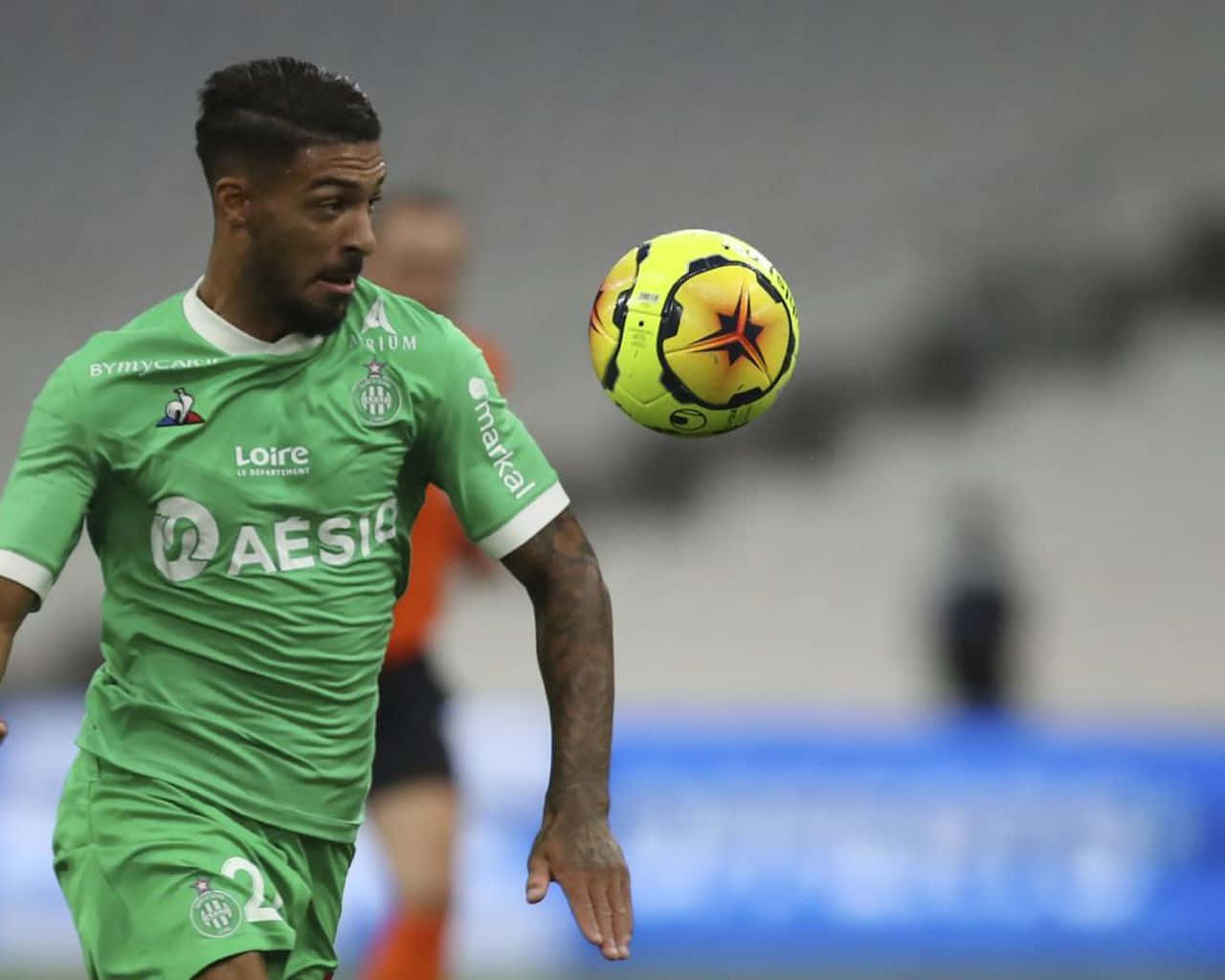 Denis Bouanga, green jersey, bright yellow ball, HD Desktop Wallpaper