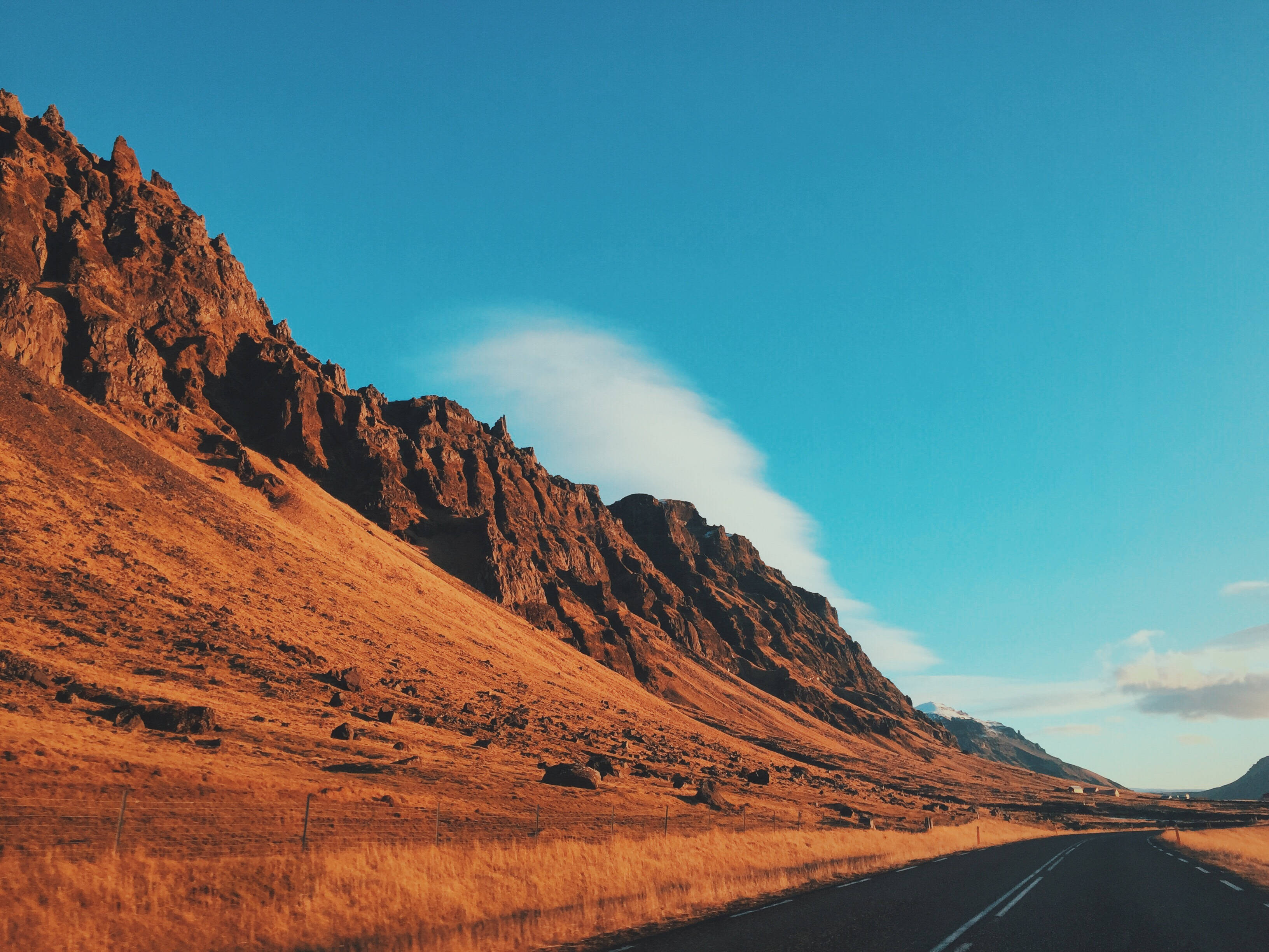 winding road, golden grasslands, vast blue sky, 2K Desktop Wallpaper
