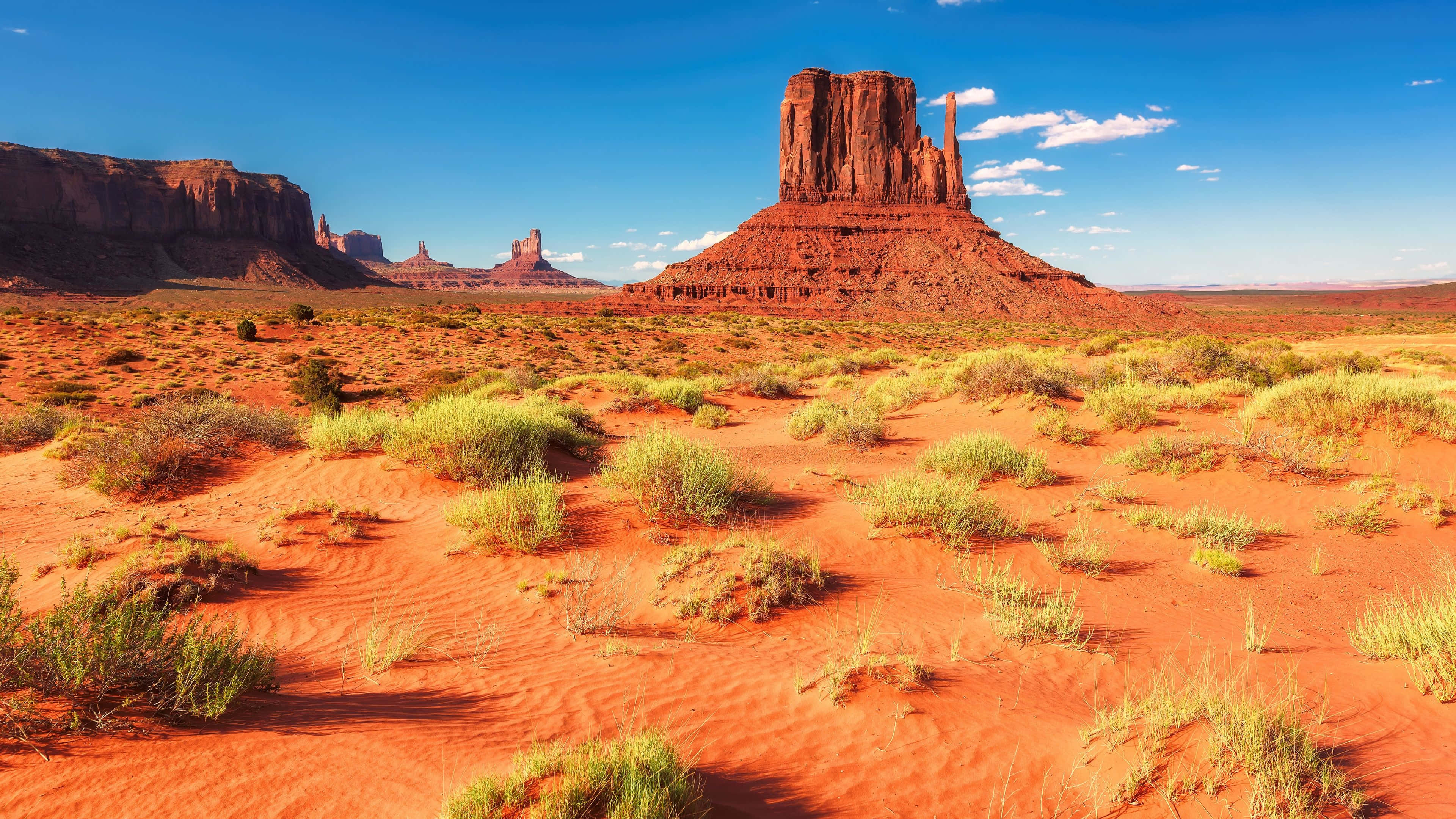red desert landscape, towering sandstone buttes, clear blue sky, 4K Desktop Wallpaper