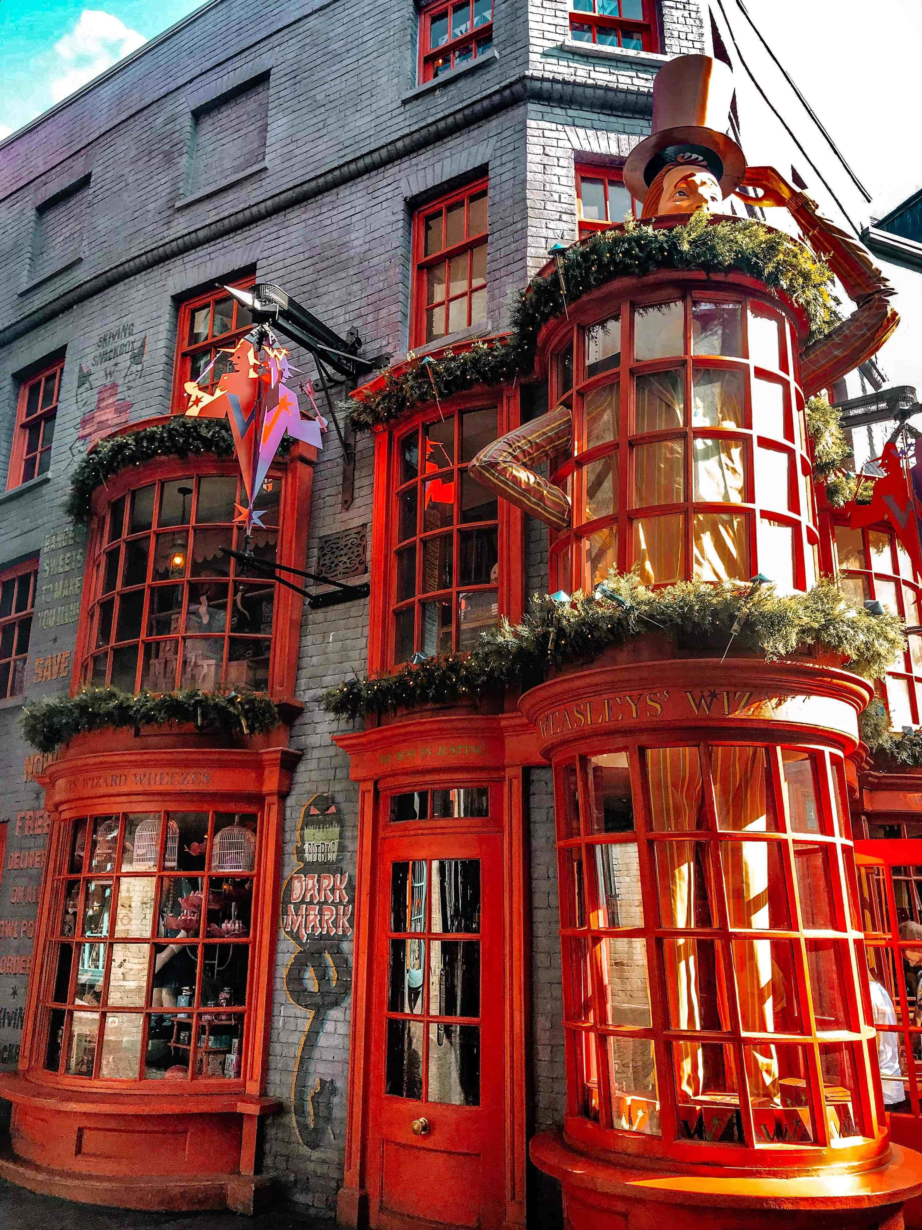 Diagon Alley, red wizarding shop fronts, festive garlands, 4K Phone Wallpaper