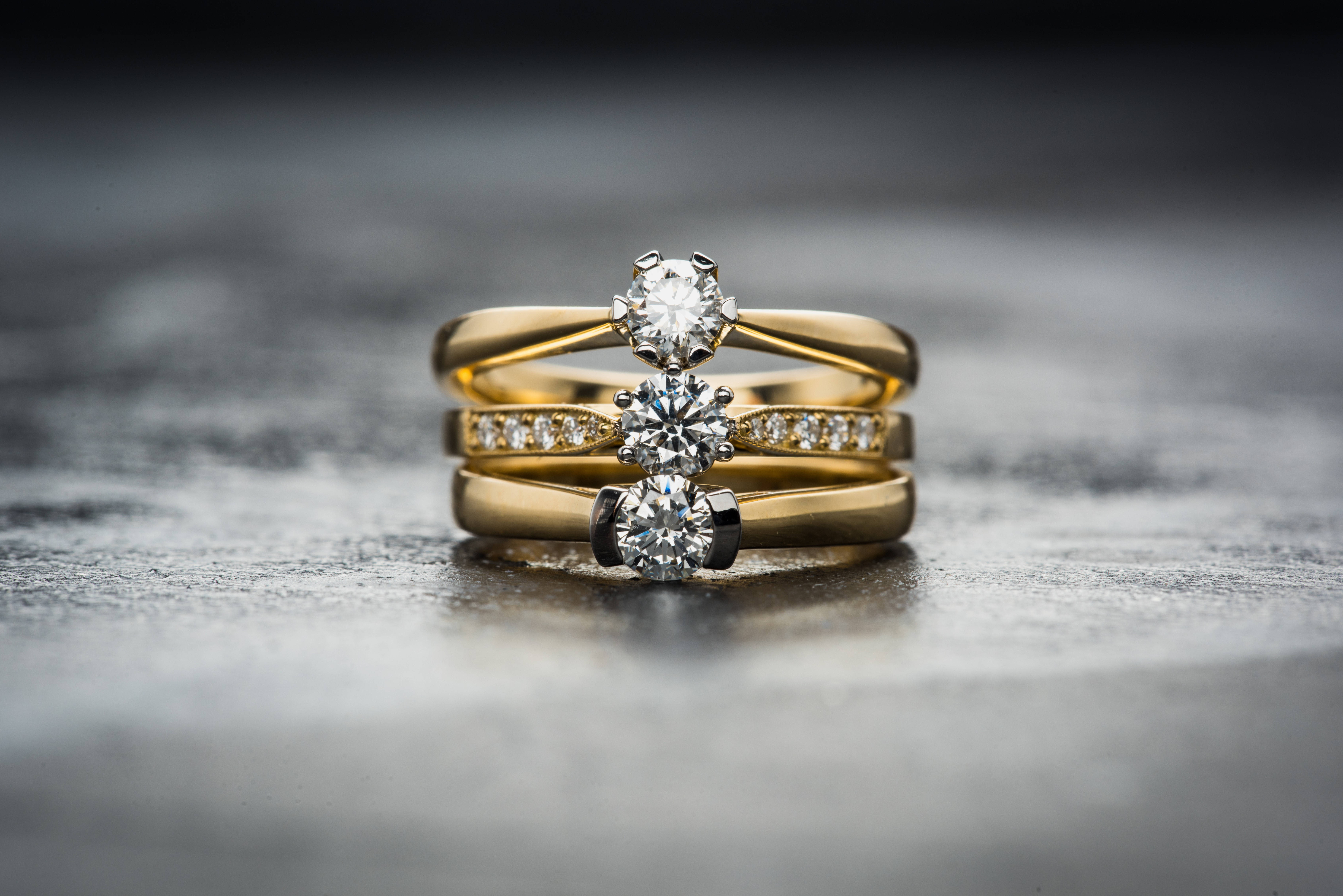 gold diamond rings, textured gray surface, soft studio lighting, 5K Desktop Wallpaper