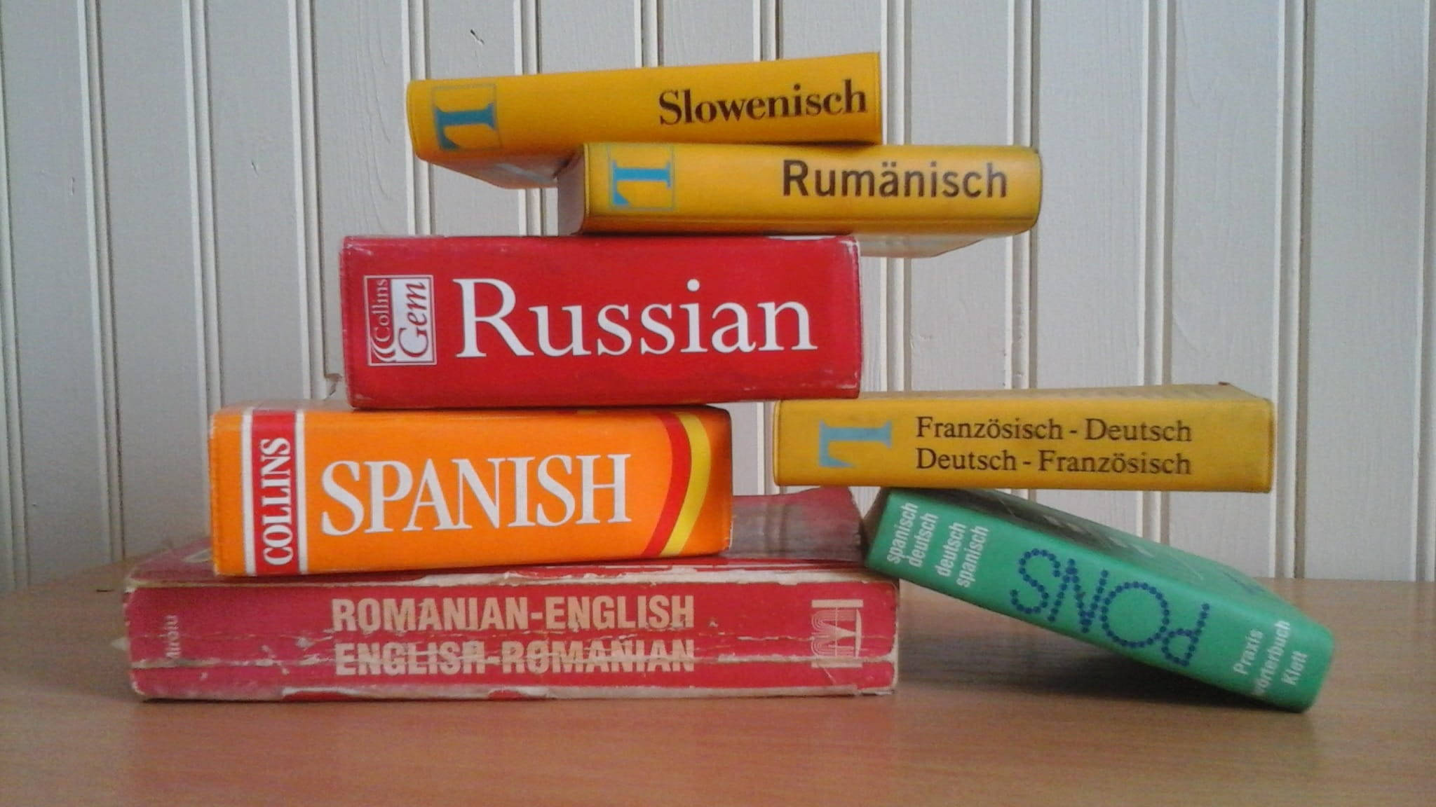 colorful dictionary book stack, vintage language learning books, wooden surface, Full HD Desktop Wallpaper