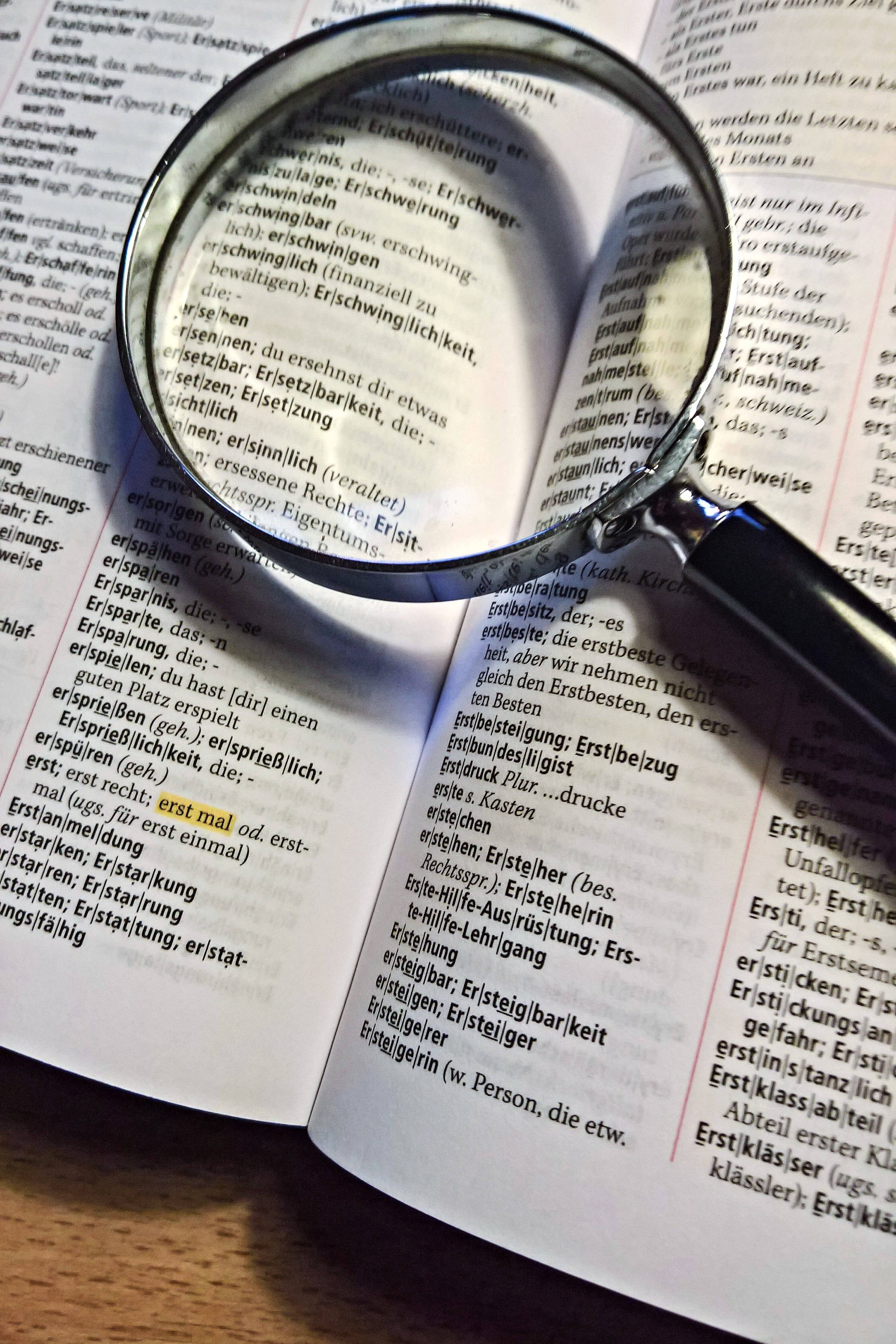 magnifying glass, German dictionary, word 'erstmal', 4K Phone Wallpaper