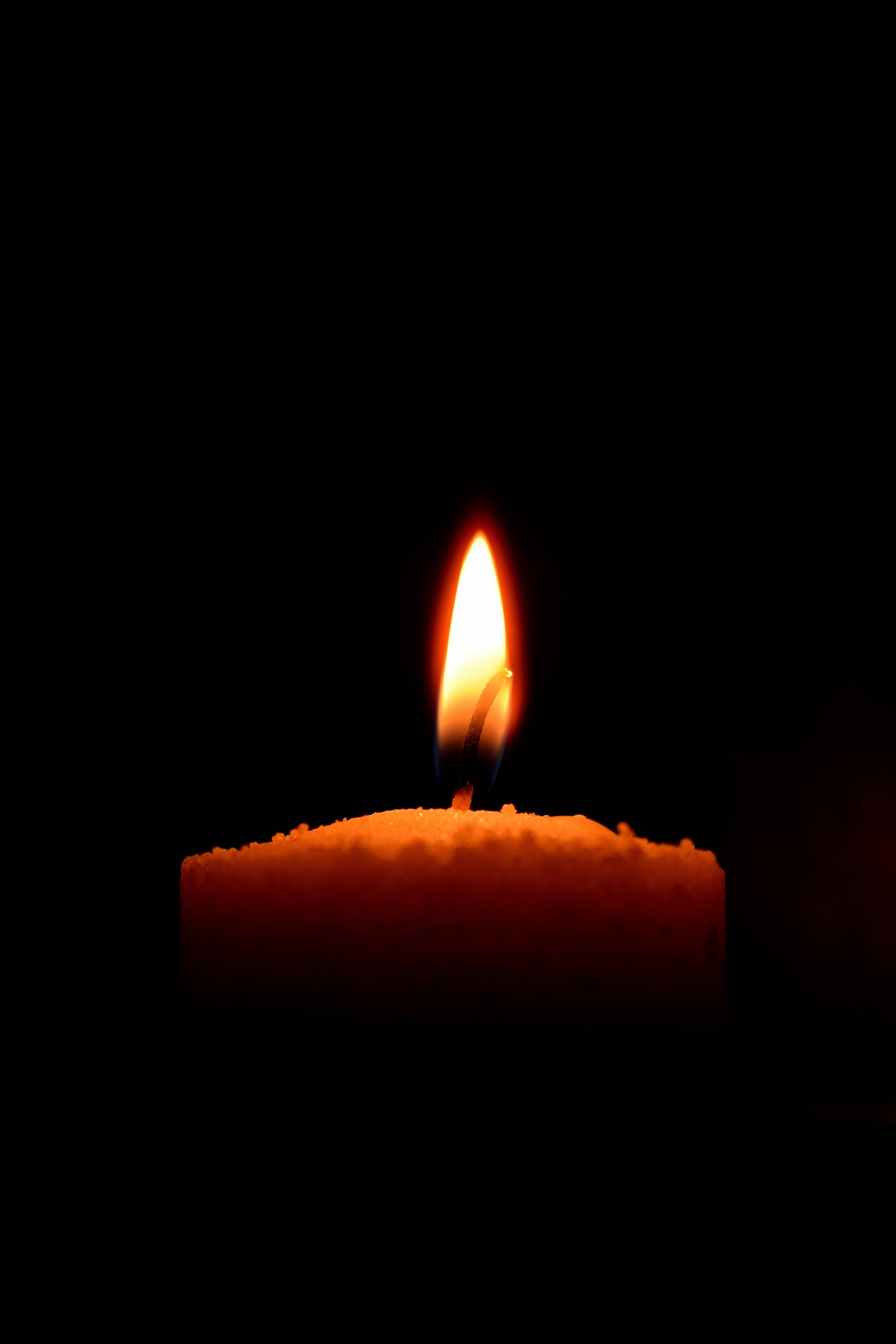 Dim, lighted candle, warm orange glow, 5K Phone Wallpaper