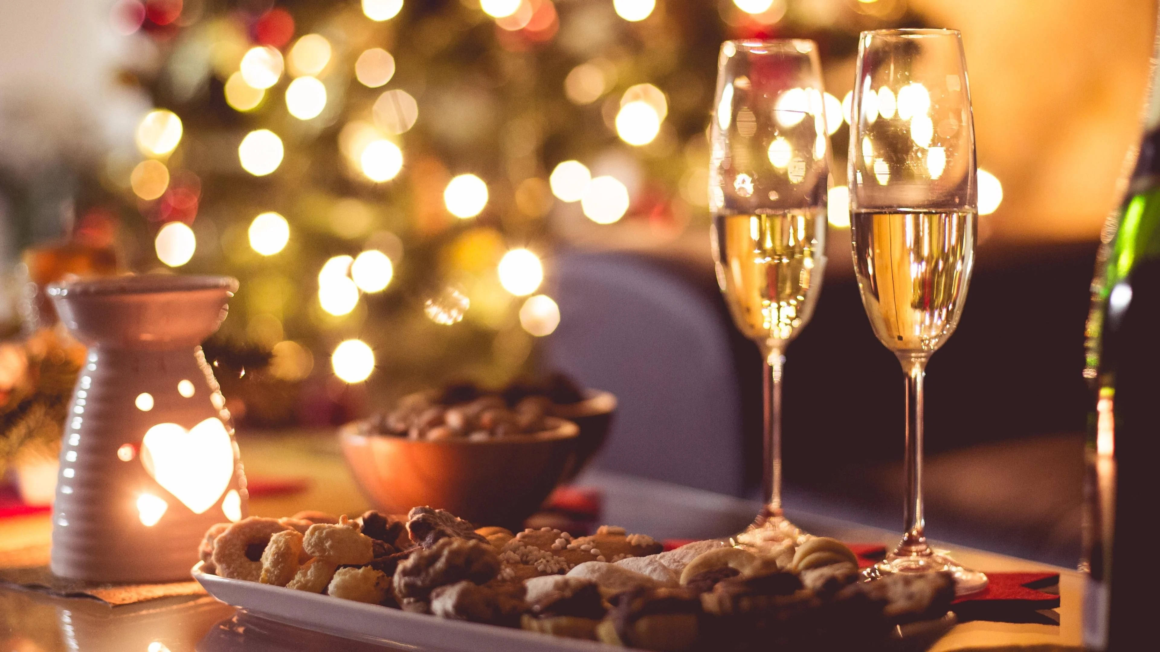 champagne flutes, festive cookies, warmly lit table, 4K Desktop Wallpaper