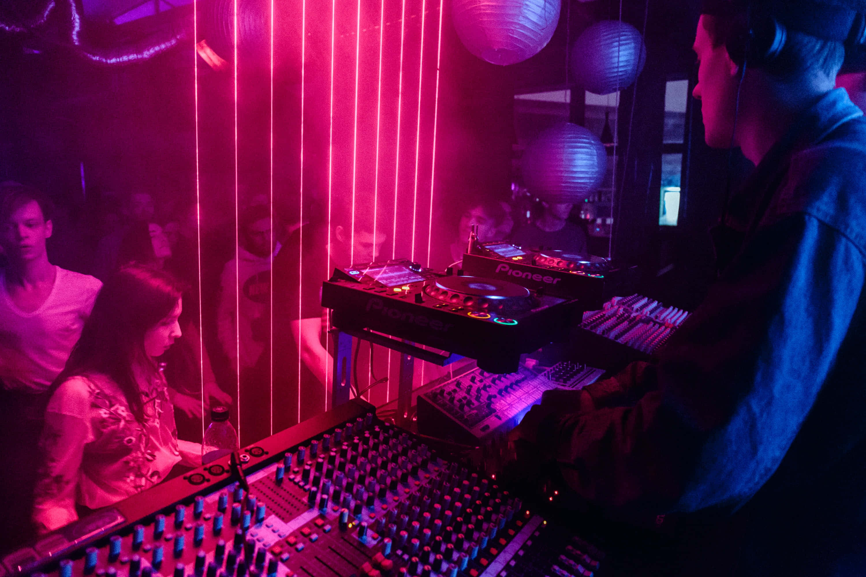 neon lit d j booth, vibrant pink neon lights, crowded nightclub, 2K Desktop Wallpaper