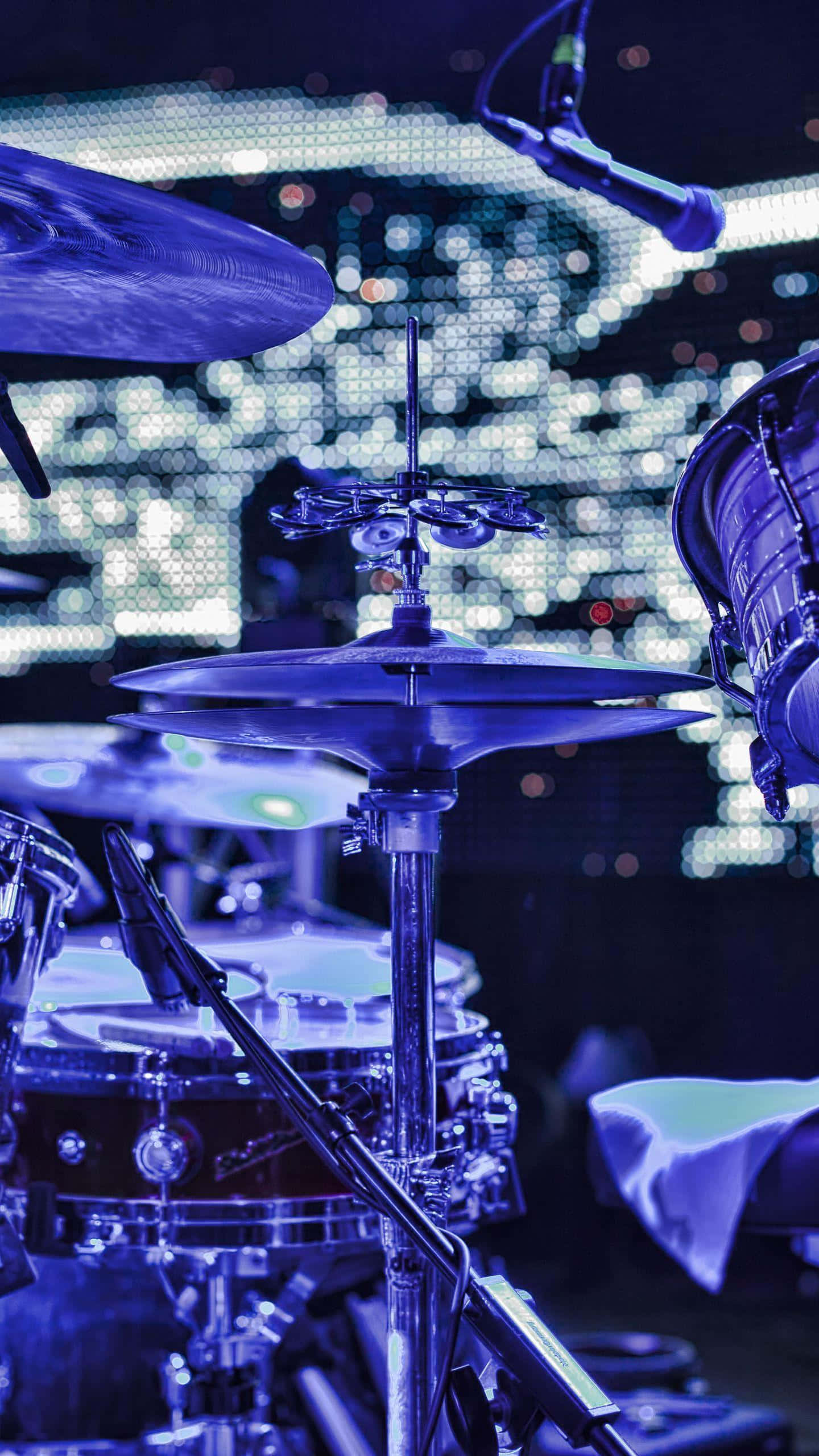 drum set, vibrant blue stage lights, glowing pixelated backdrop, 2K Phone Wallpaper
