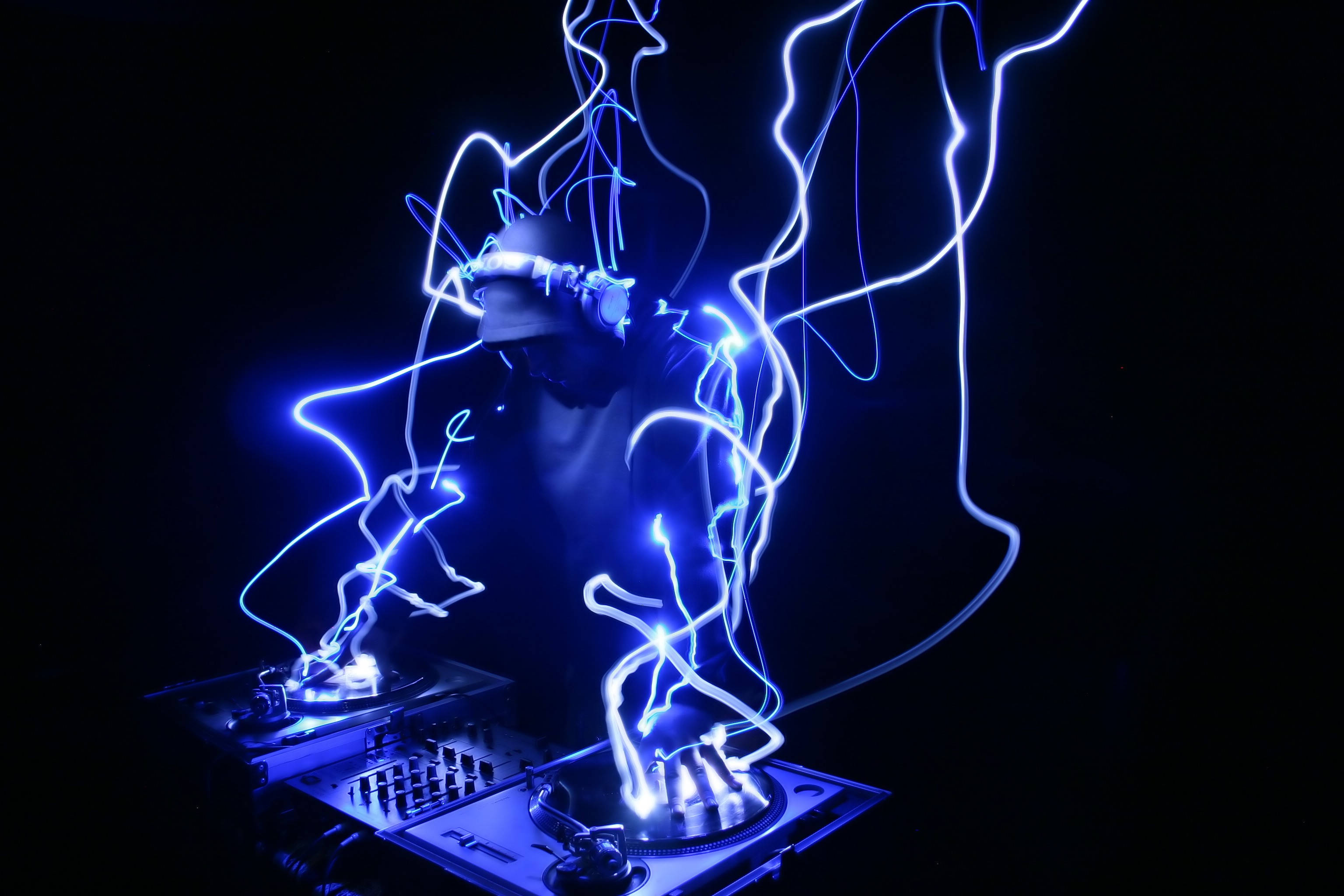 DJ, dark room, glowing blue light trails, 2K Desktop Wallpaper