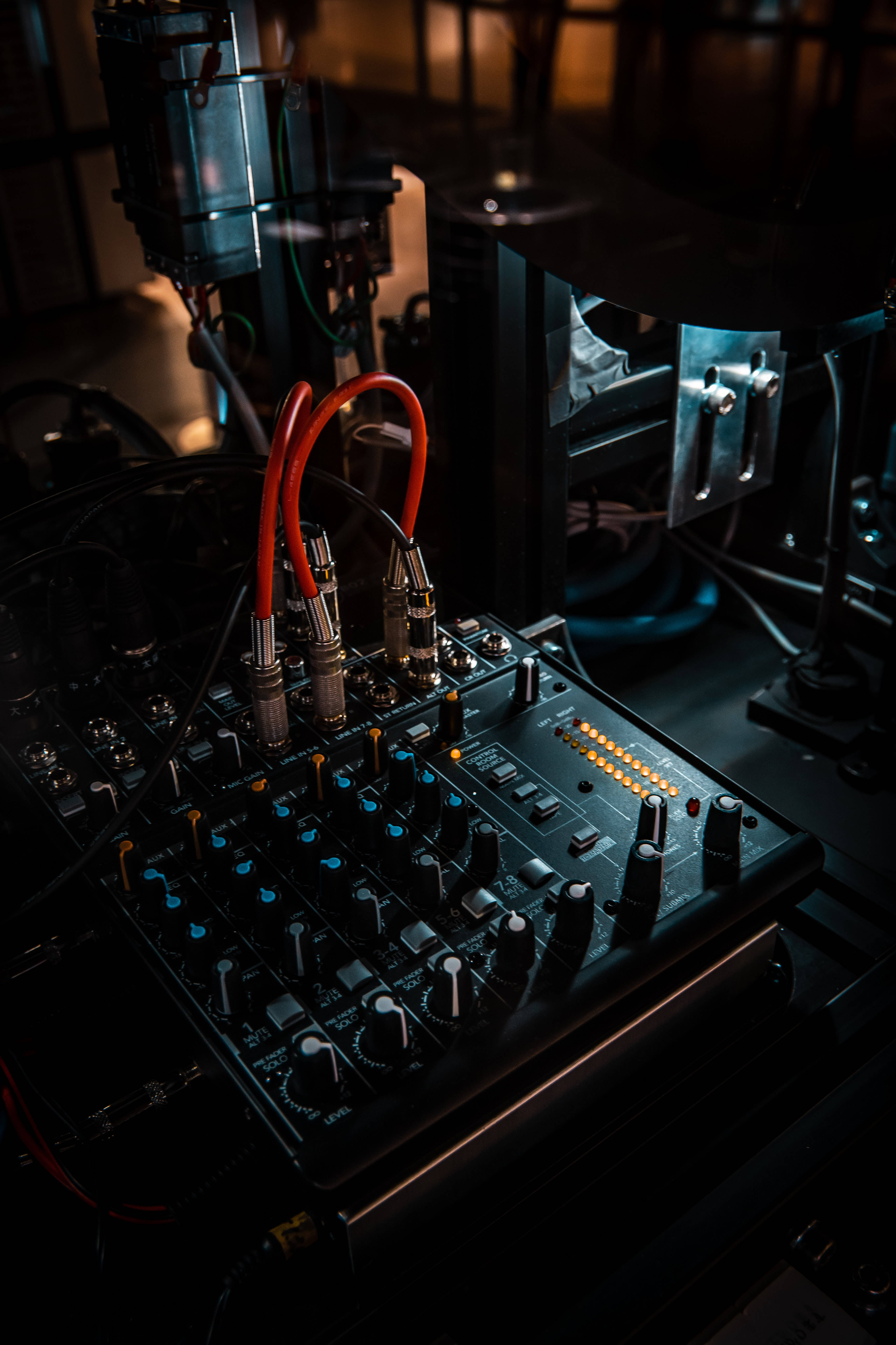 black audio mixer, glowing blue knobs, orange cables, 5K Phone Wallpaper