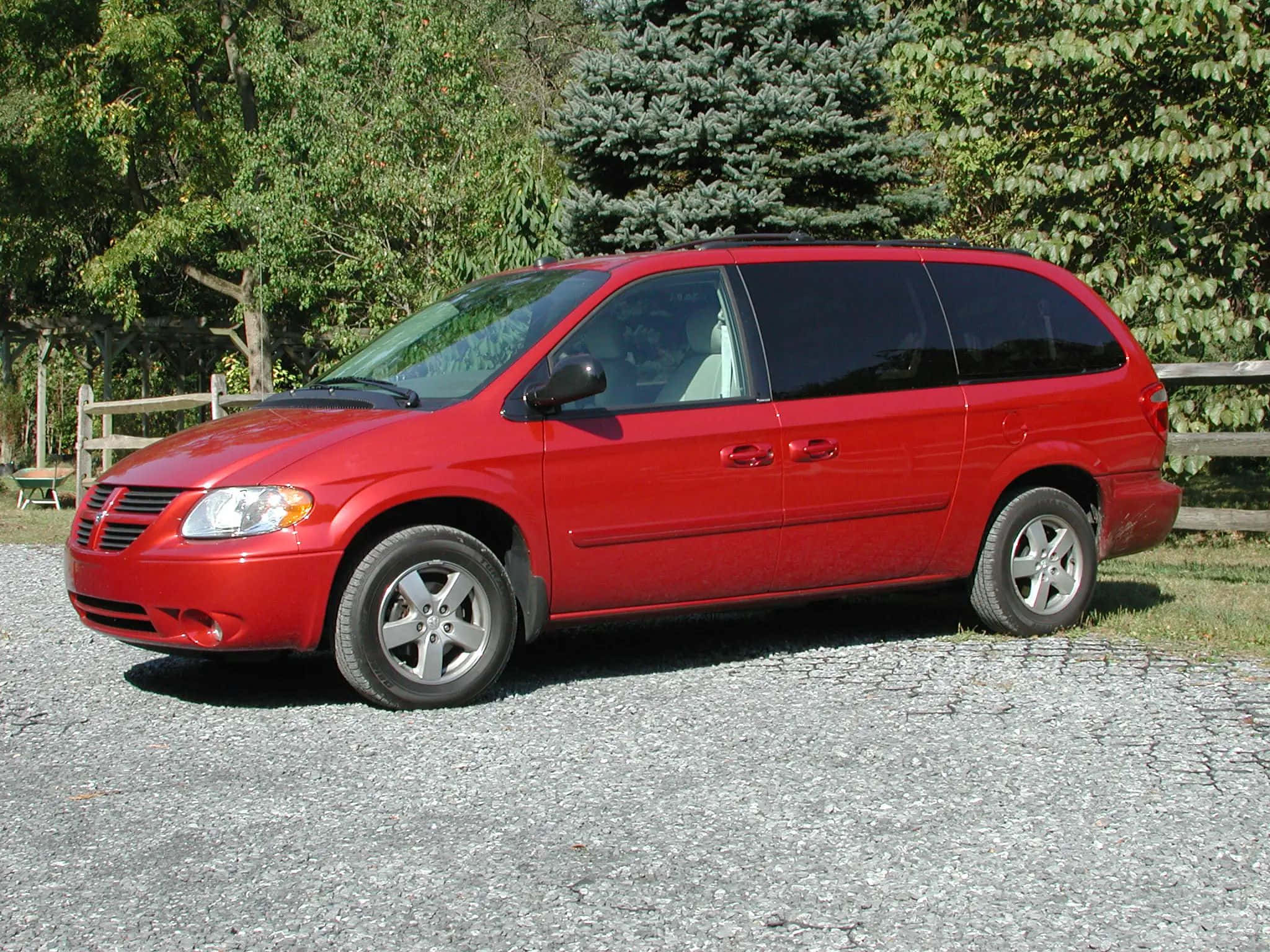 Red Dodge Grand Caravan, gravel driveway, lush green trees, Full HD Desktop Wallpaper
