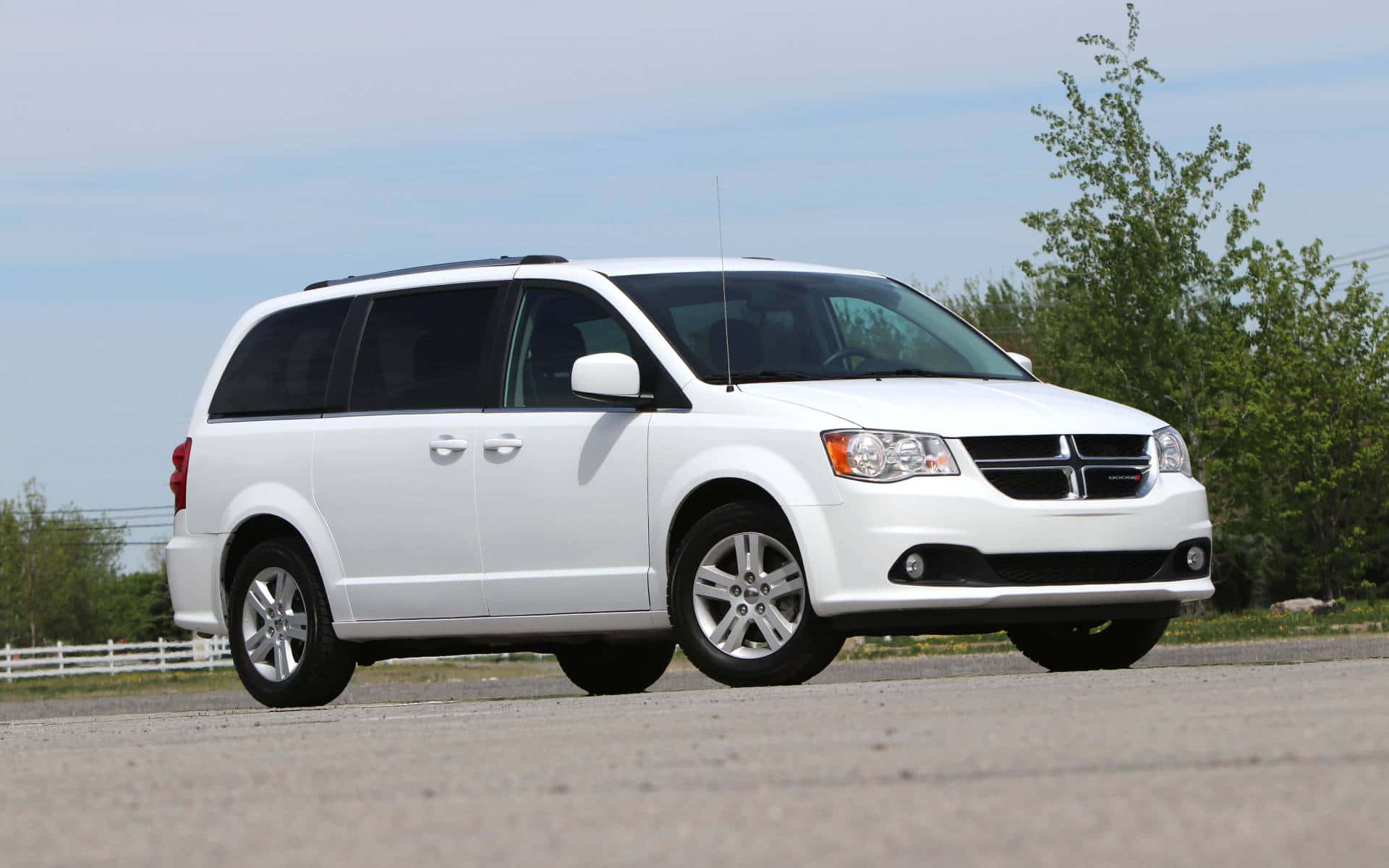 White Dodge Grand Caravan, asphalt lot, green trees, Full HD Desktop Wallpaper