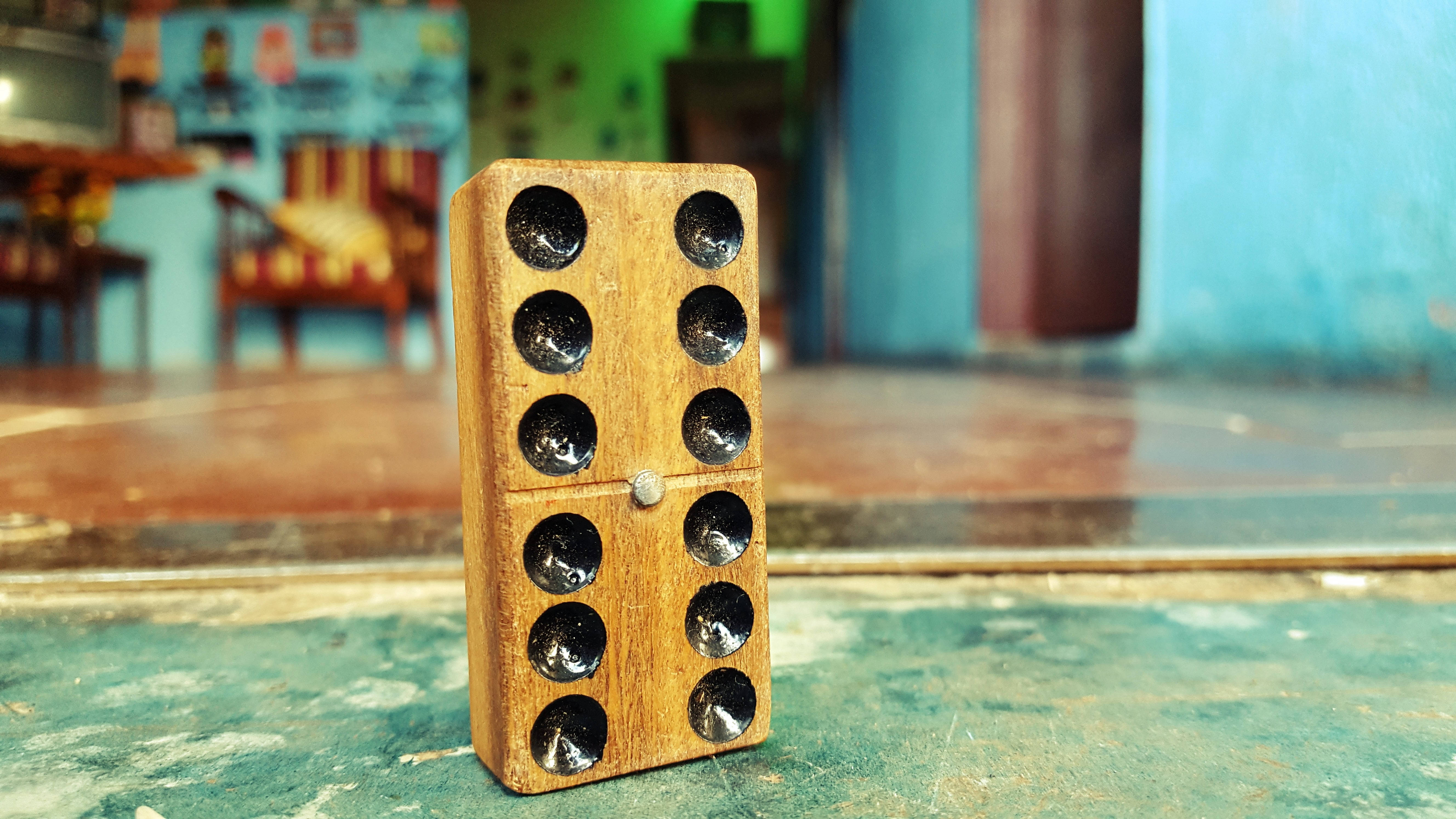 single wooden domino piece, black pips, weathered green surface, 5K Desktop Wallpaper