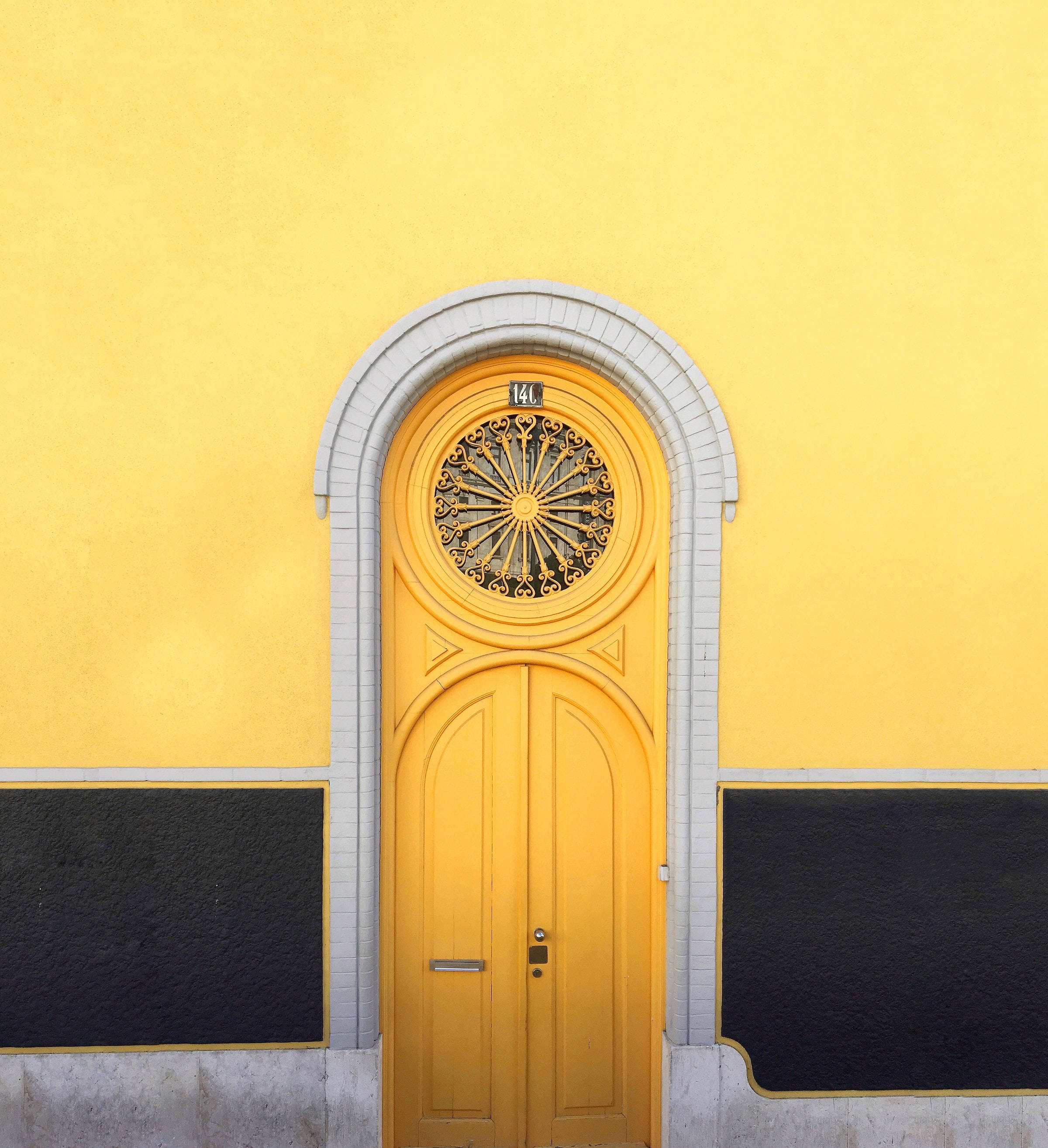 vintage yellow wooden double door, arched door, ornate metalwork, 2K Phone Wallpaper
