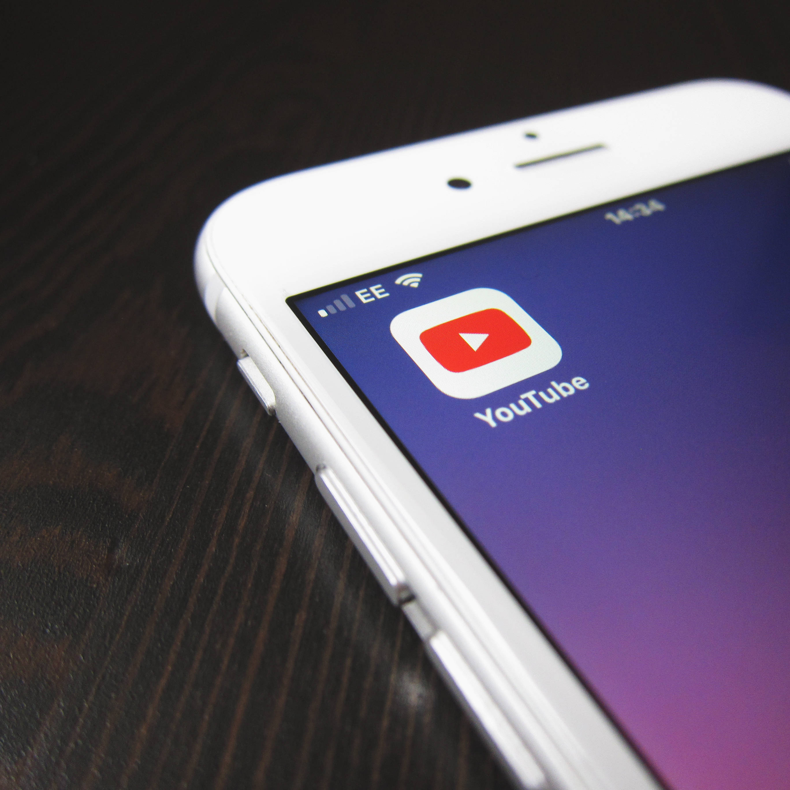 YouTube app icon, purple gradient screen, white smartphone, 2K Desktop Wallpaper