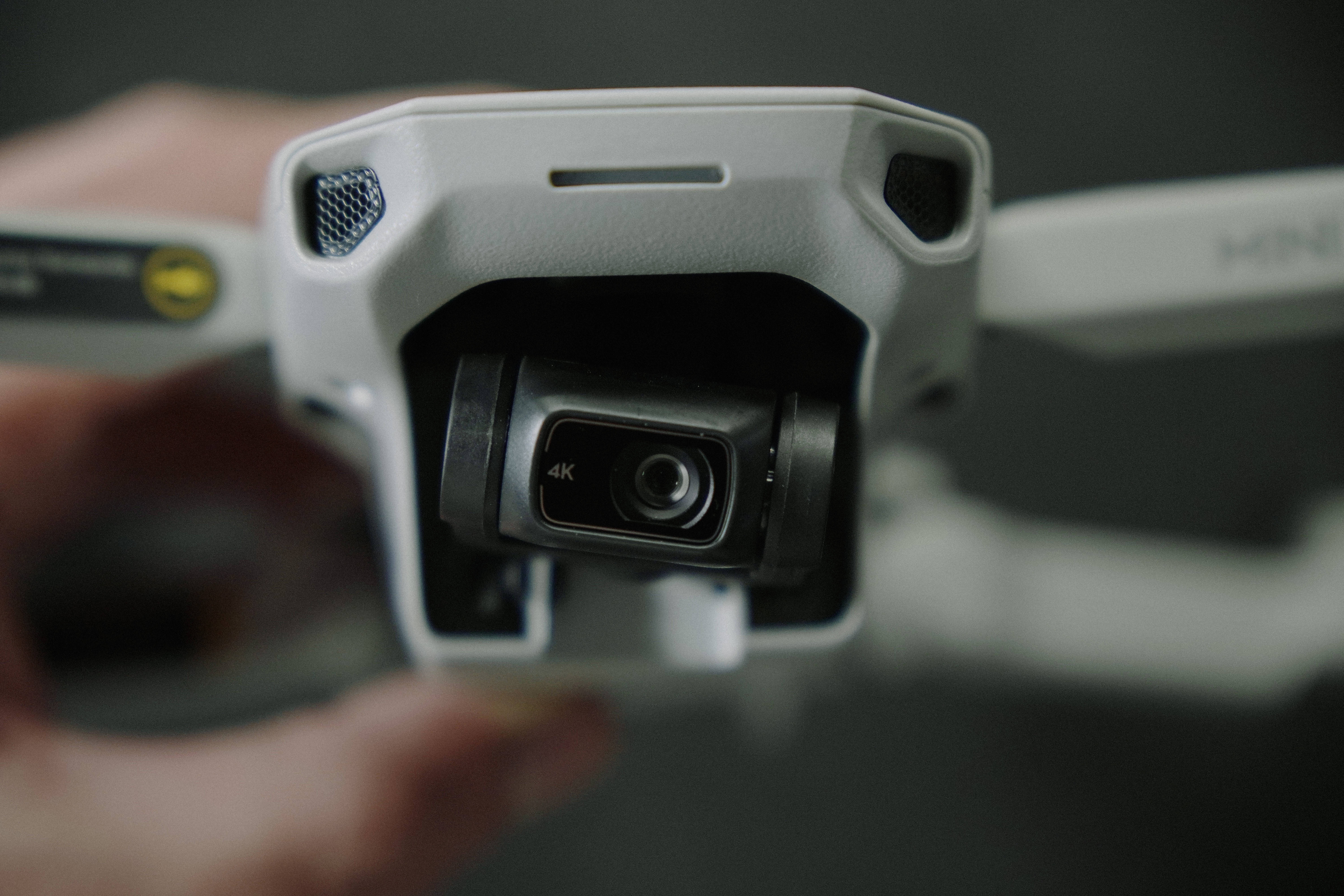 white drone, 4K camera lens, dark blurred background, 5K Desktop Wallpaper