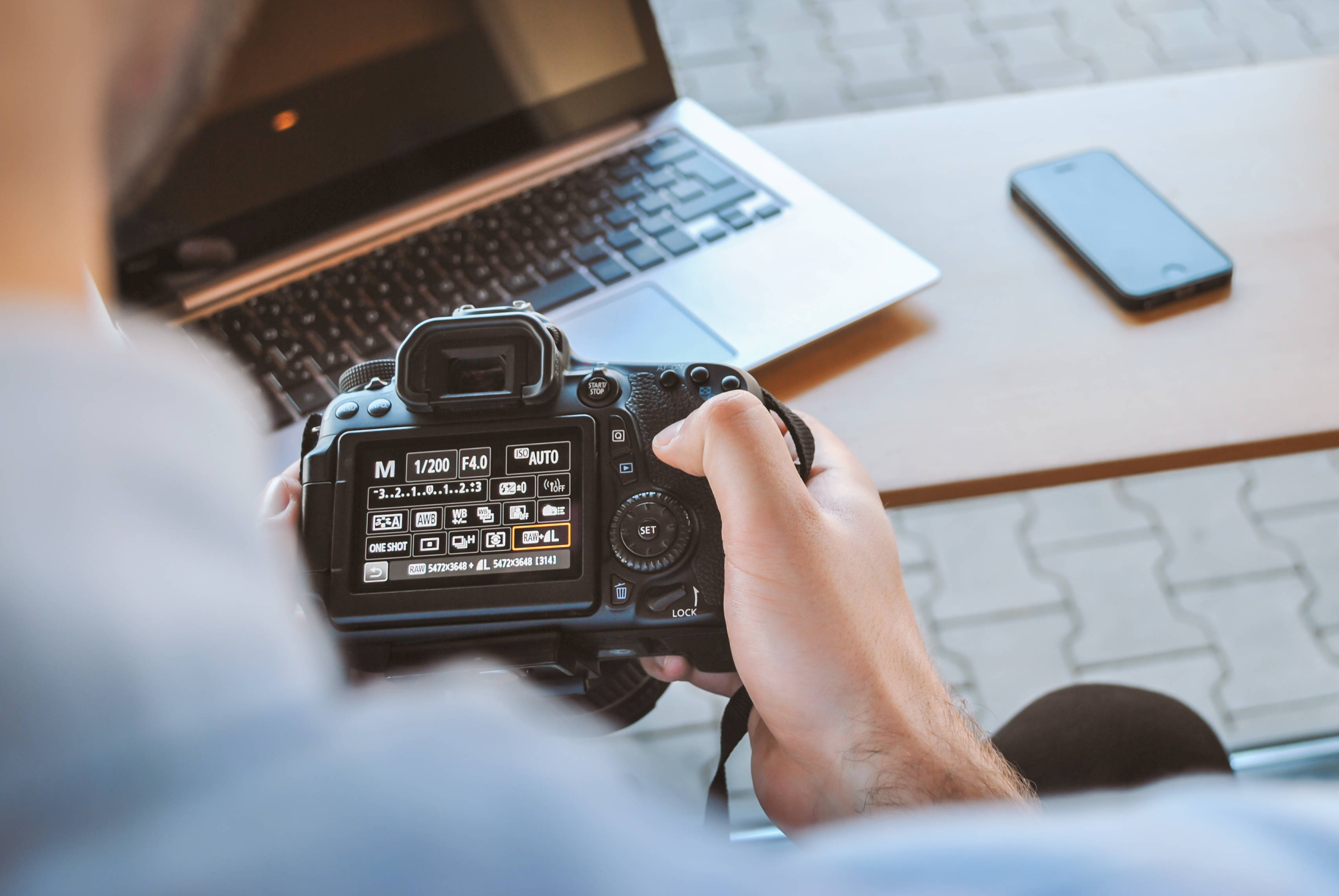 DSLR camera, black dslr camera, person holding, 2K Desktop Wallpaper