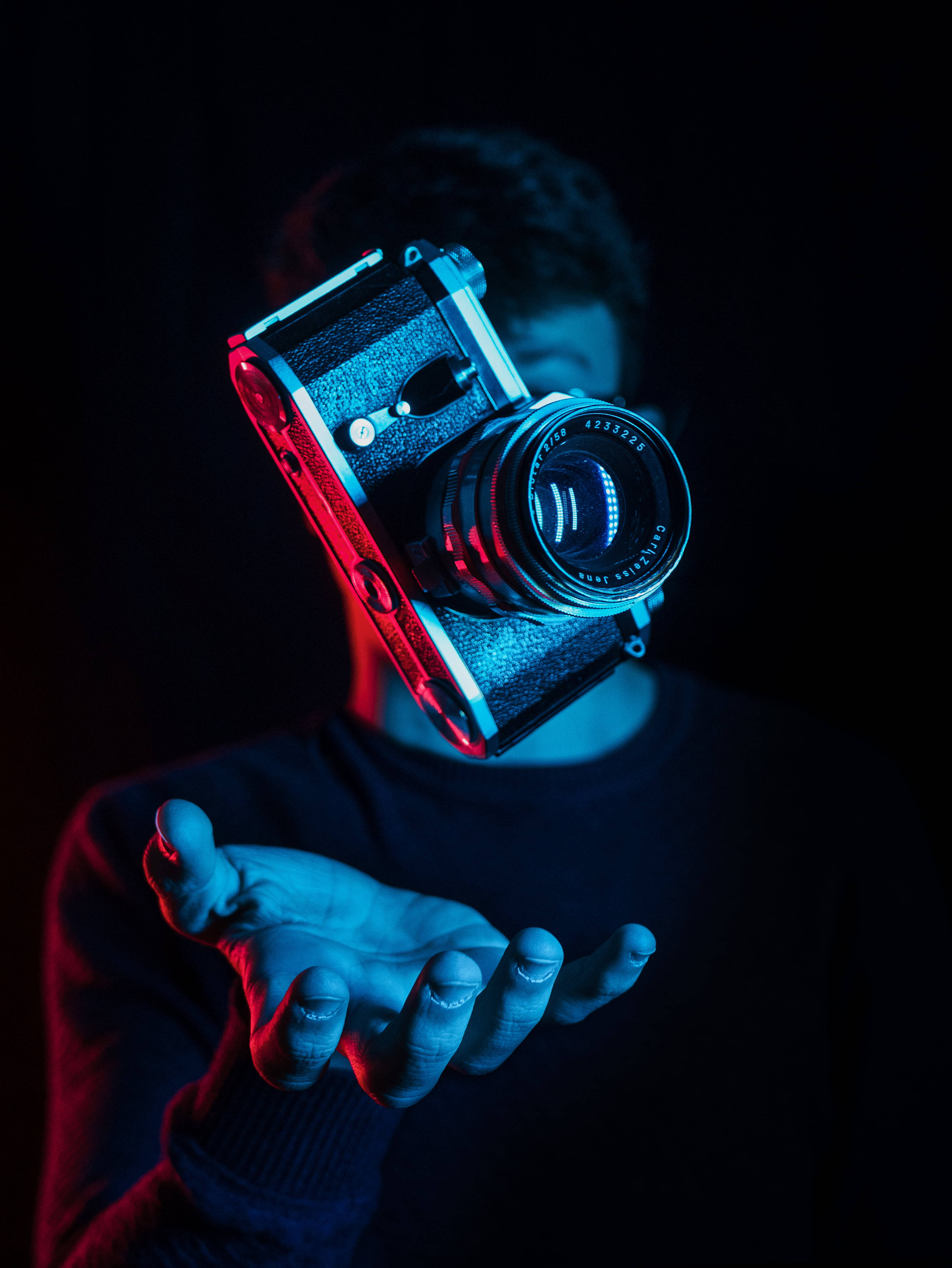 vintage camera, dramatic red and blue neon lighting, black background, 4K Phone Wallpaper