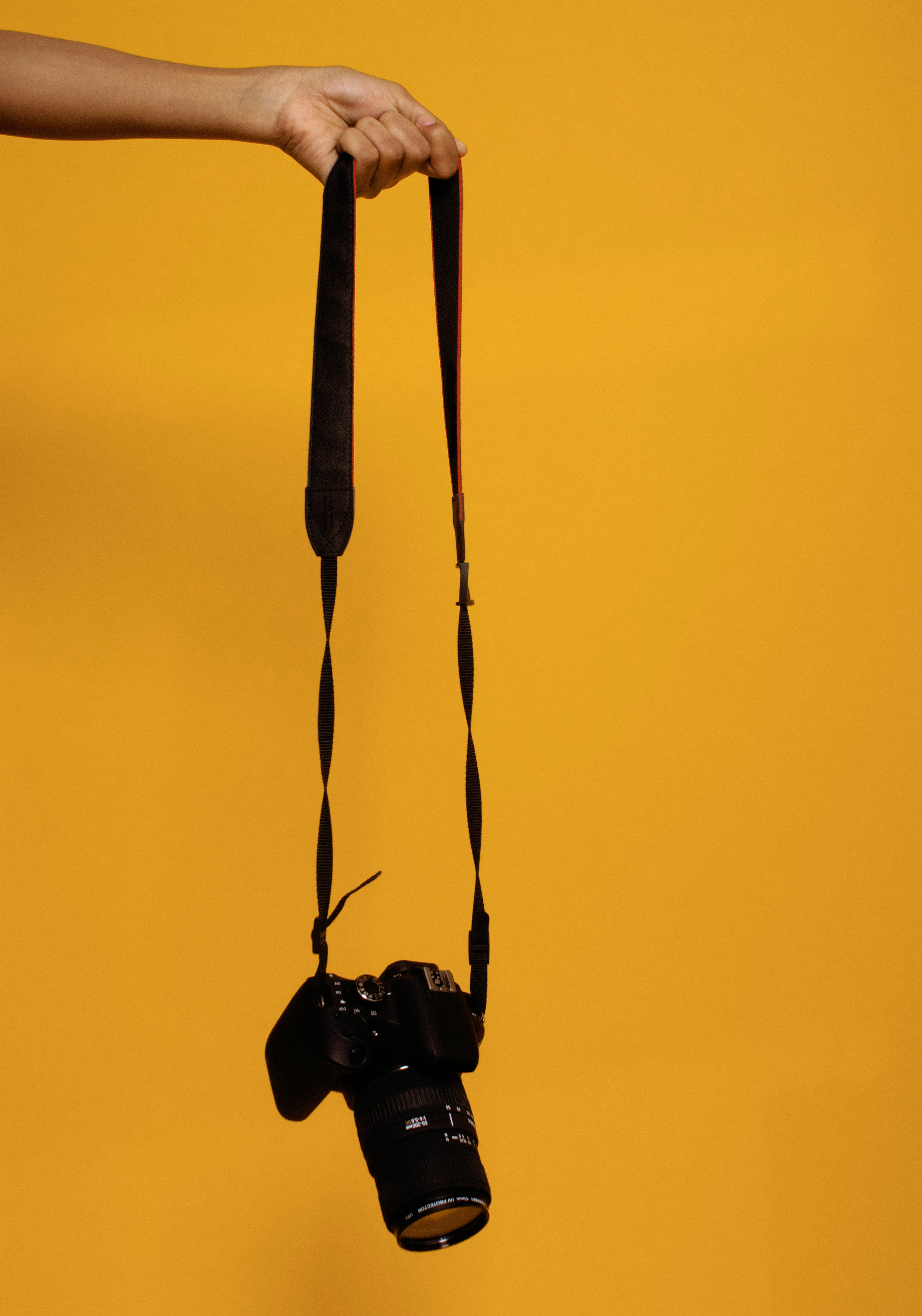 black DSLR camera, custard yellow, solid warm yellow background, 5K Phone Wallpaper