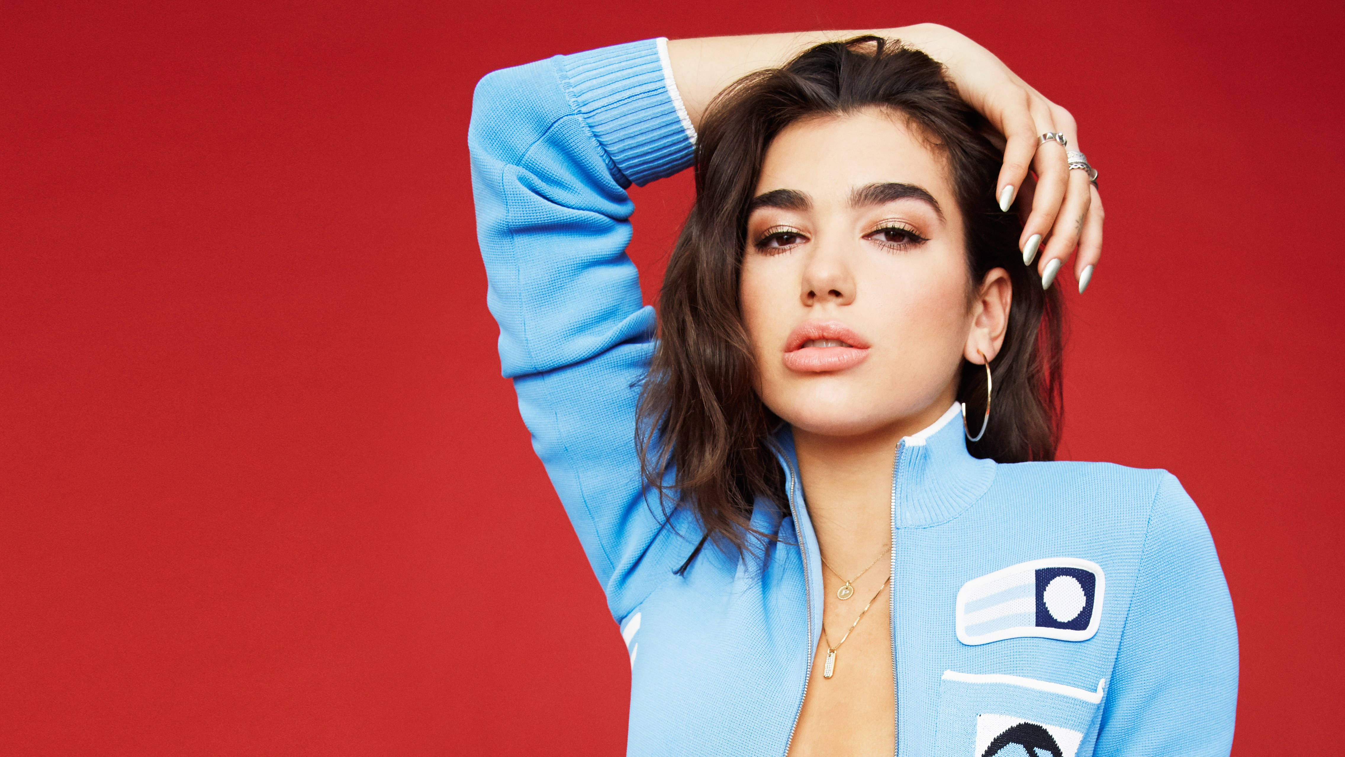 Dua Lipa, light blue zip-up jacket, bold red background, 4K Desktop Wallpaper