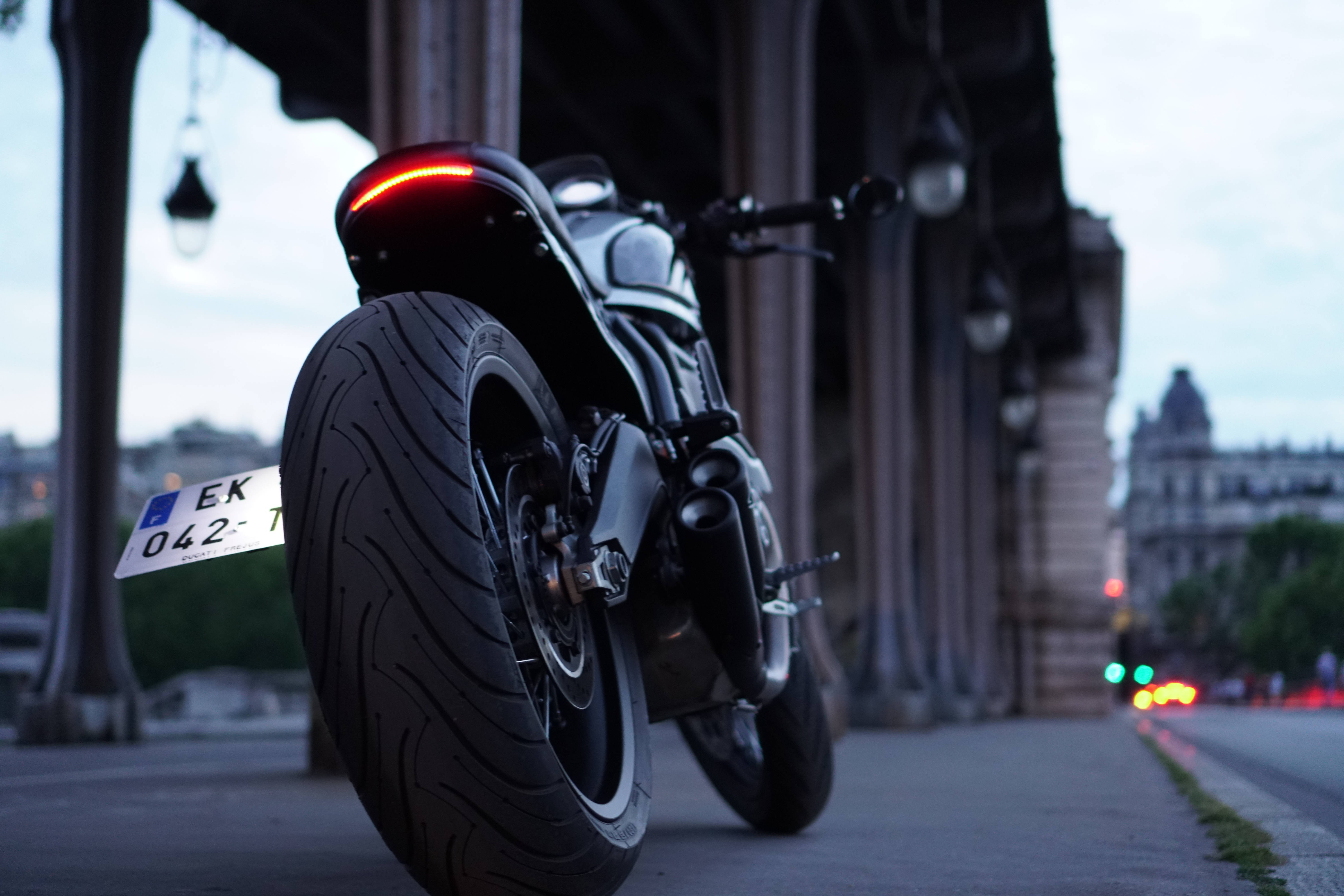 black Ducati, glowing red taillight, stone bridge, 5K Desktop Wallpaper