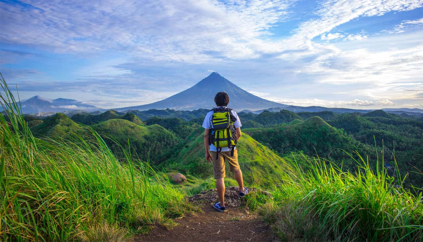 bright green backpack, grassy ridge, majestic cone-shaped volcano, HD Desktop Wallpaper