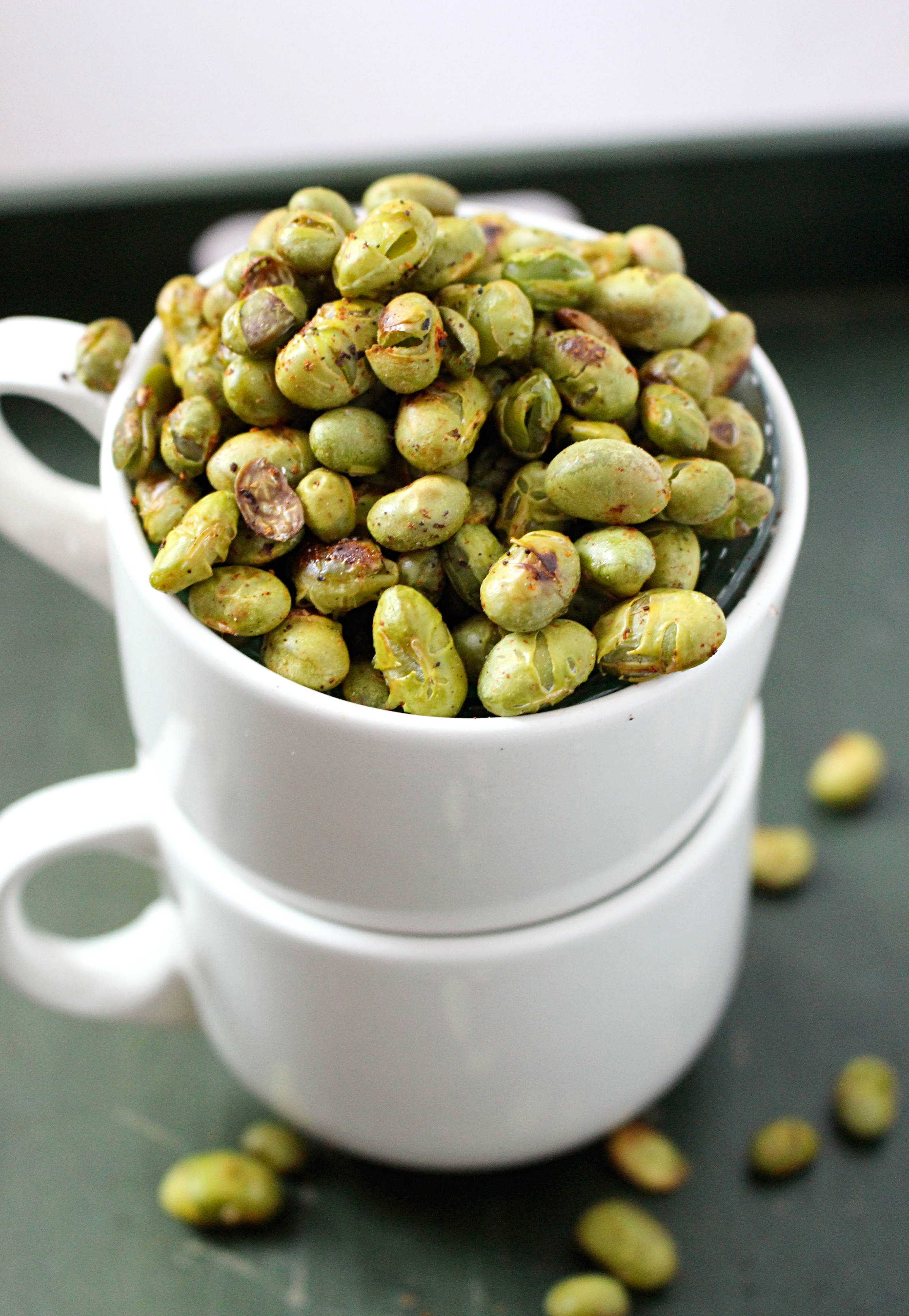 white ceramic mug, roasted green edamame beans, dark surface, 2K Phone Wallpaper