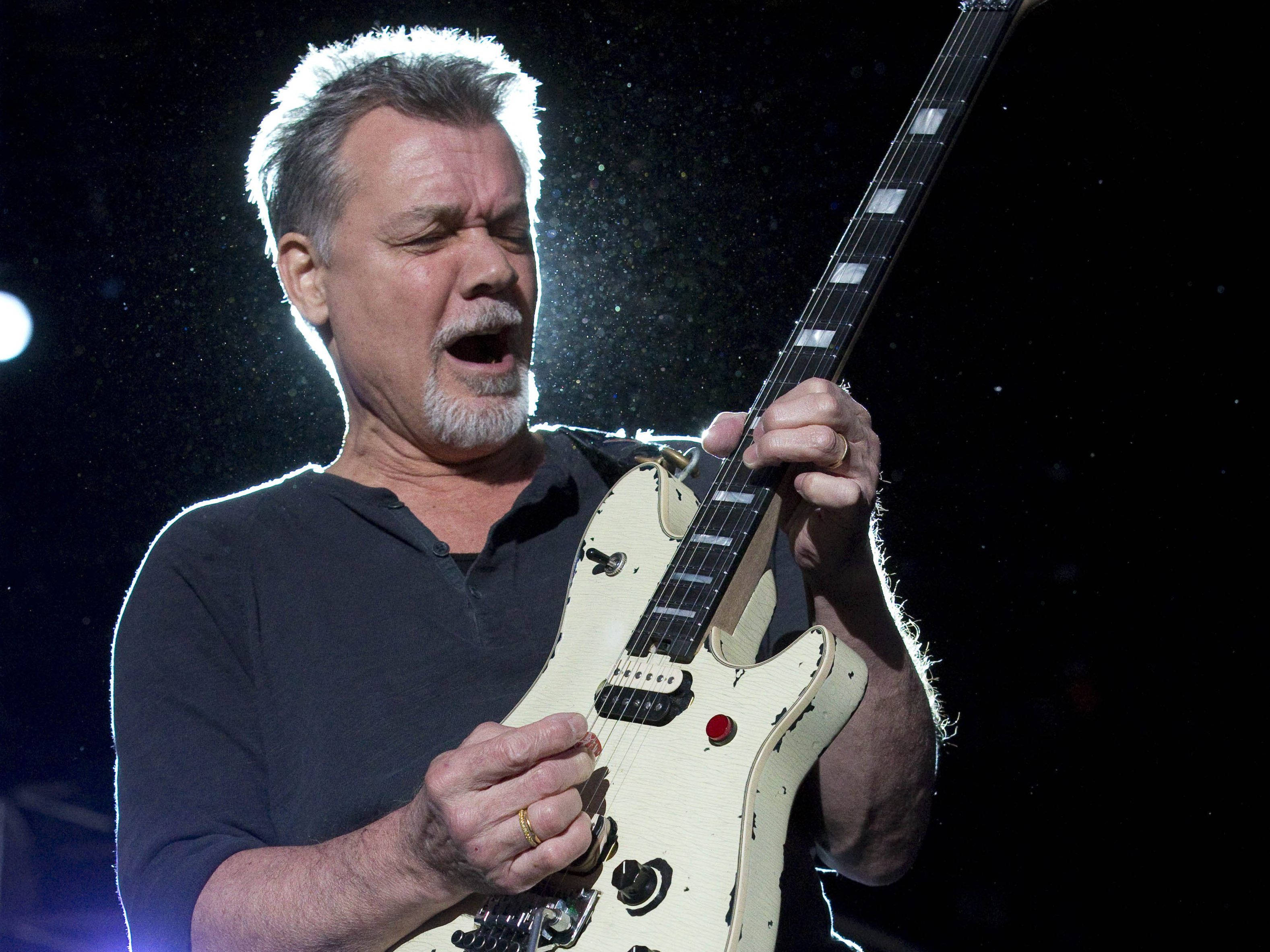 Eddie Van Halen, distressed cream-colored electric guitar, bright stage lights, 2K Desktop Wallpaper