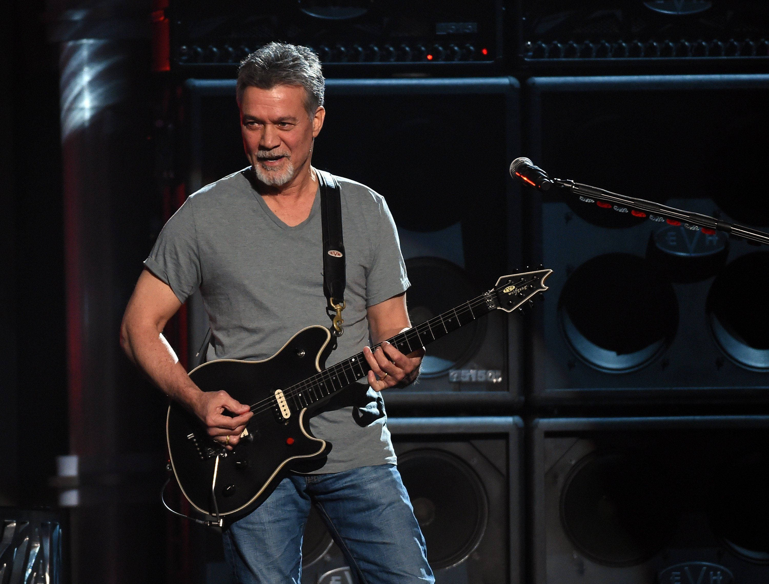 Eddie Van Halen, black electric guitar, dimly lit stage, 2K Desktop Wallpaper
