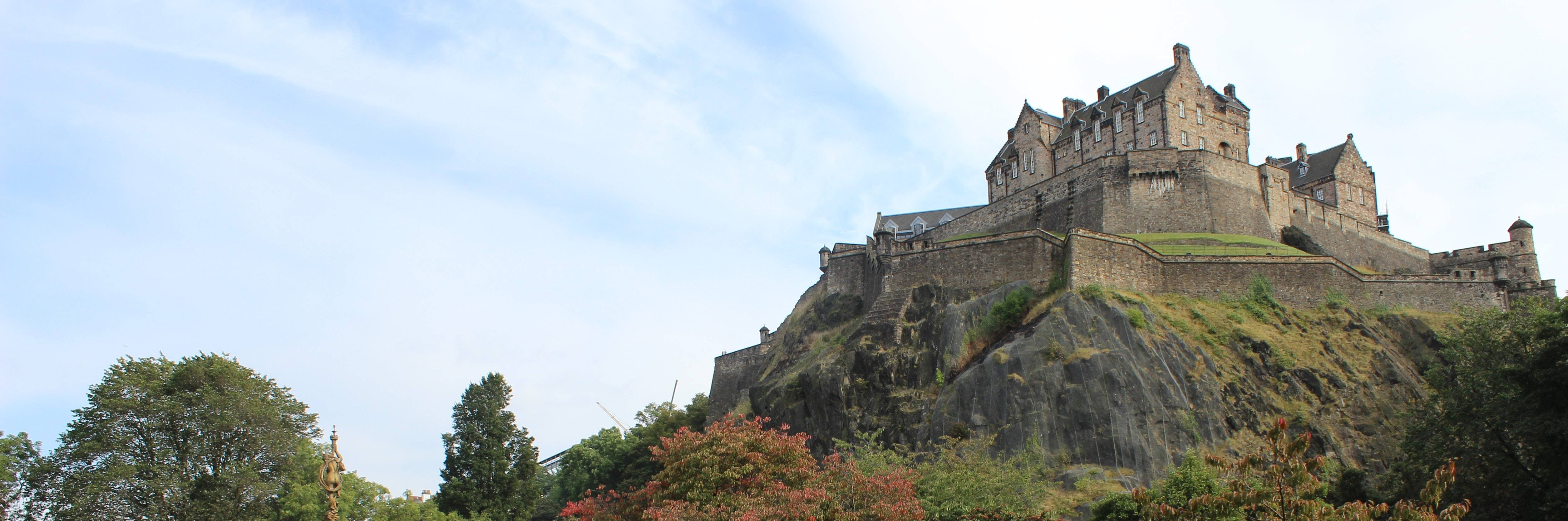Edinburgh Castle, autumn-hued trees, partly cloudy sky, 4K Desktop Wallpaper