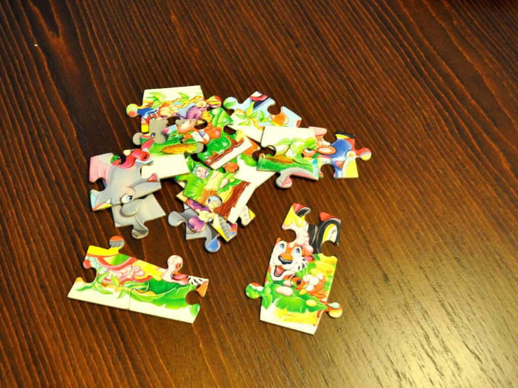colorful cartoon animal puzzle pieces, warm wooden table surface, childrens puzzle pieces, SD Desktop Wallpaper