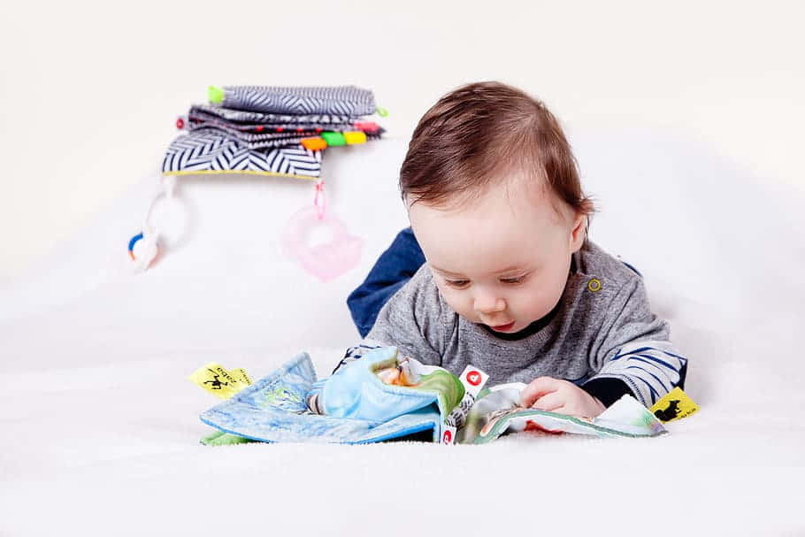 baby, colorful textured fabric toy, soft white blanket, SD Desktop Wallpaper