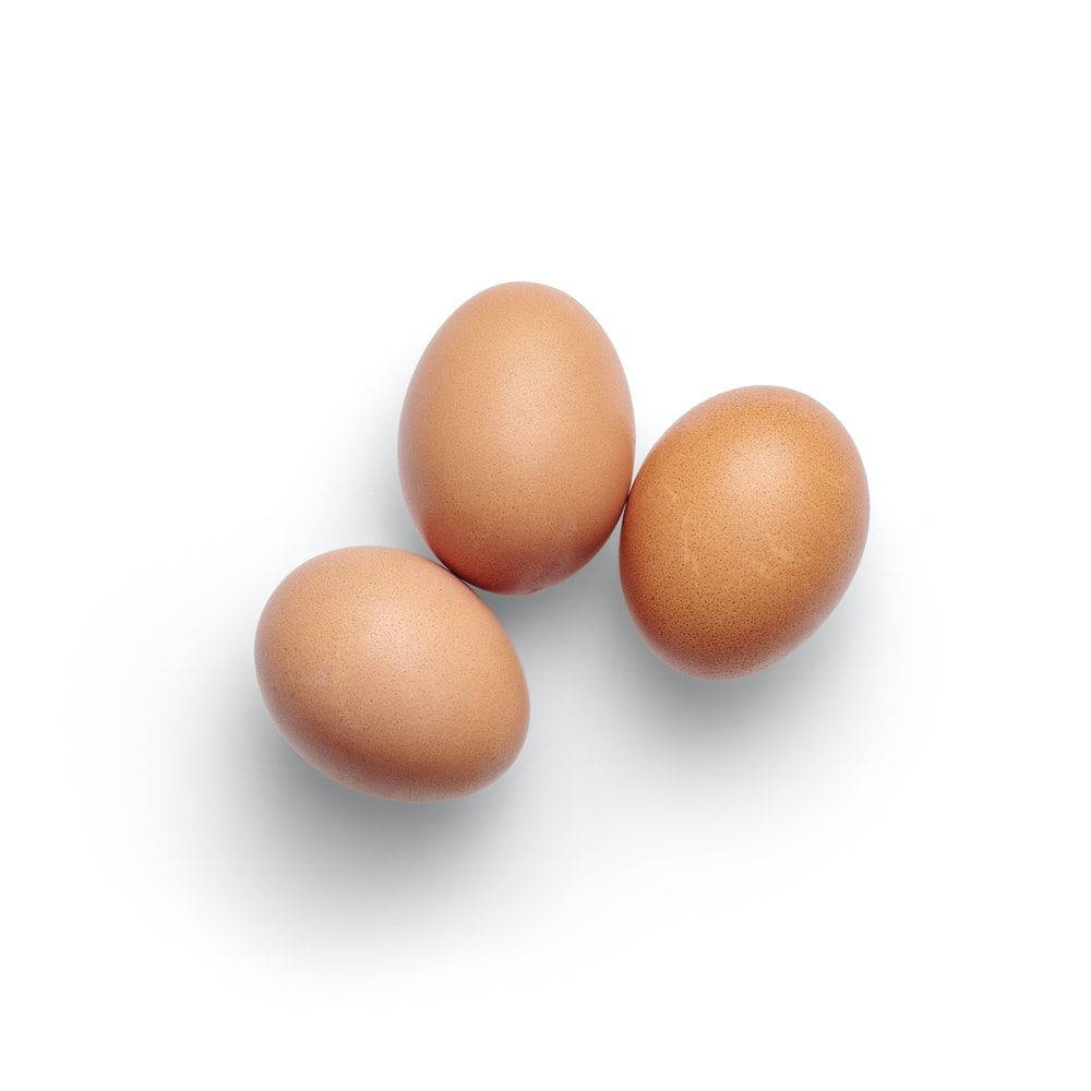 three free ranged eggs, smooth brown eggs, bright white background, SD Desktop Wallpaper