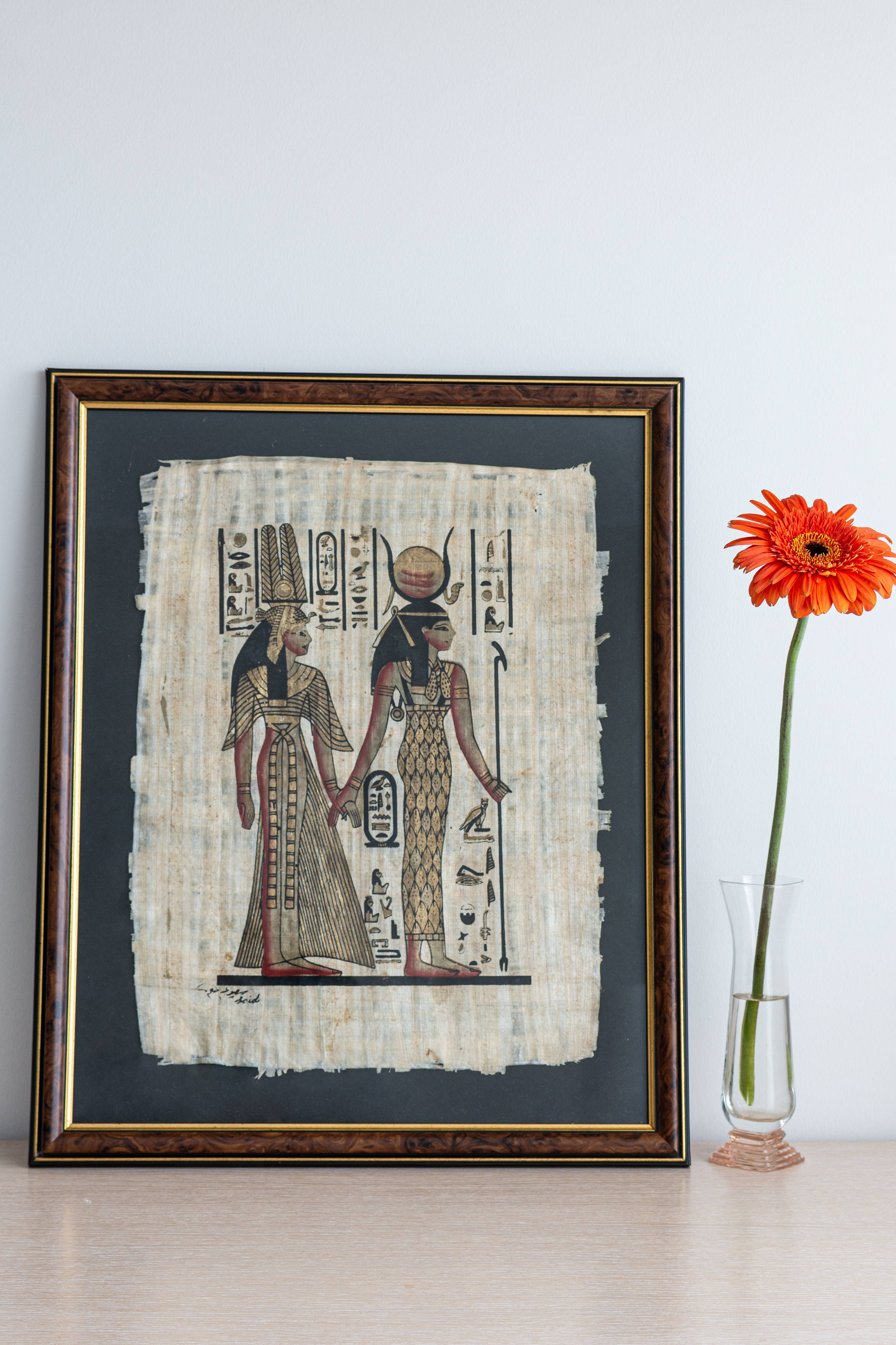 ancient Egyptian papyrus artwork, two figures in traditional attire, wooden frame, 4K Phone Wallpaper