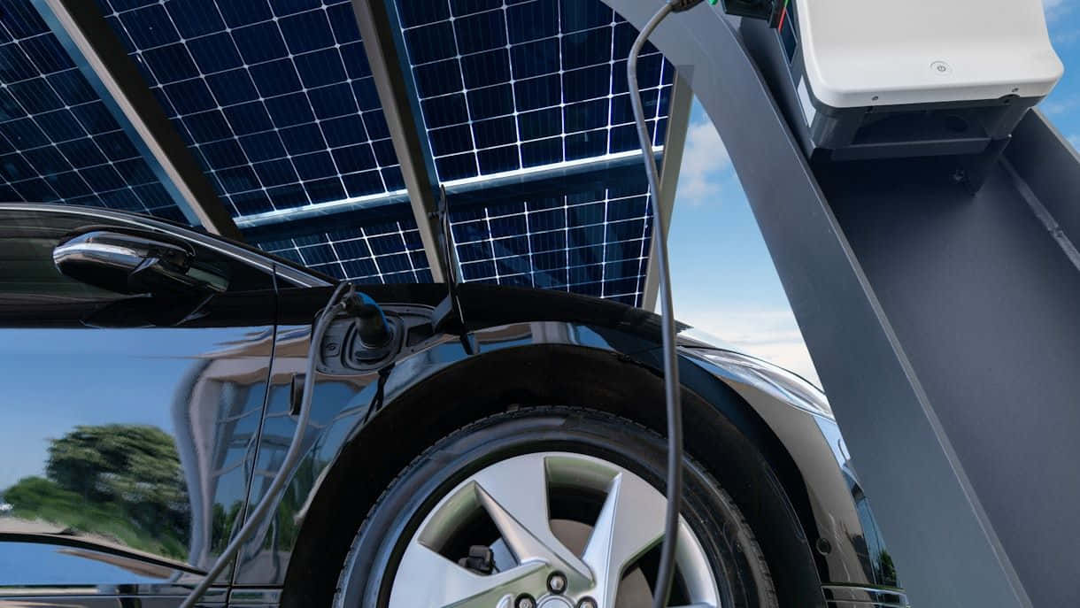 sleek black electric car, solar panel array, bright sunny day, SD Desktop Wallpaper