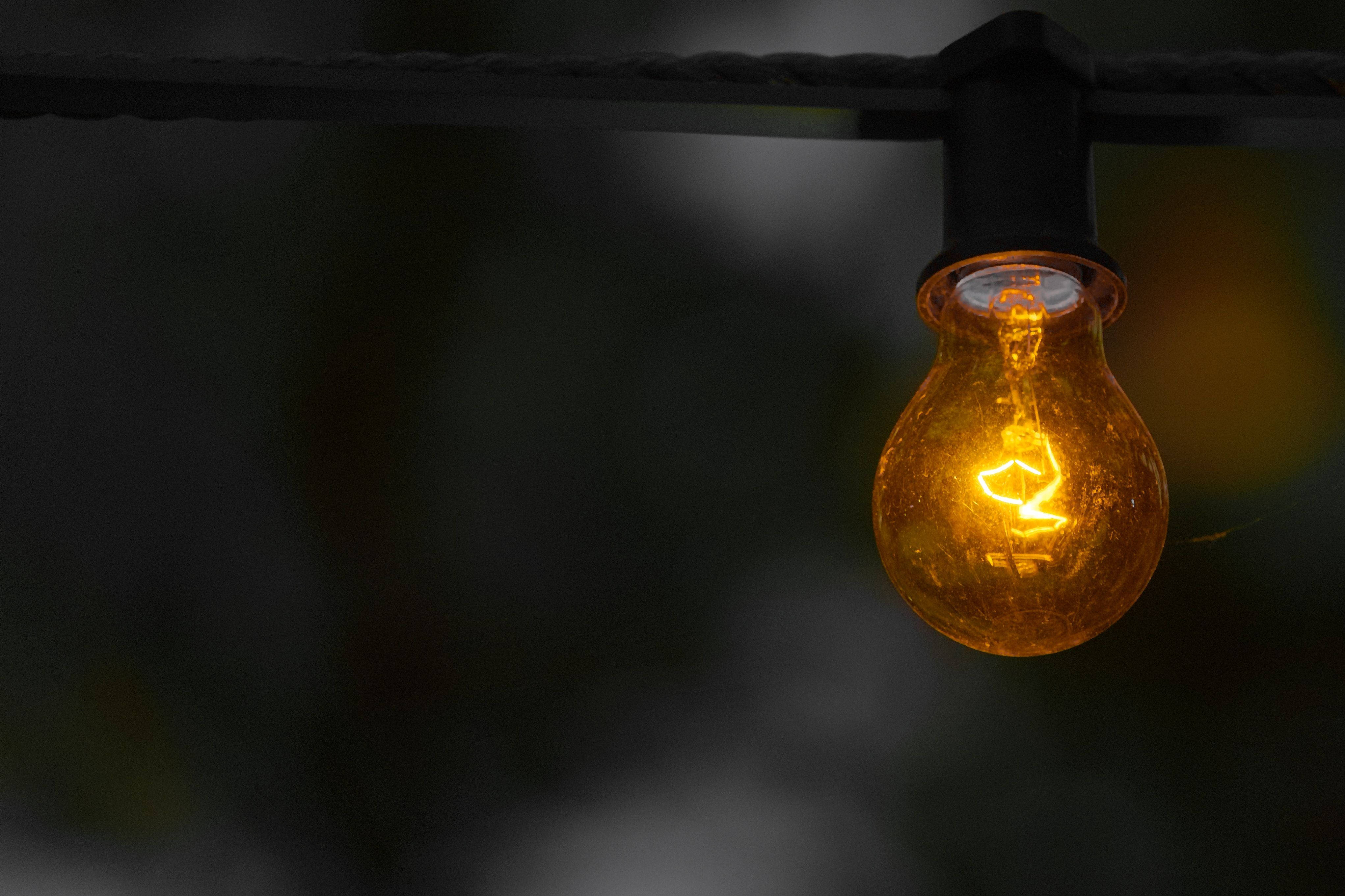 golden electricity powered light bulb, amber filament, black wire, 4K Desktop Wallpaper