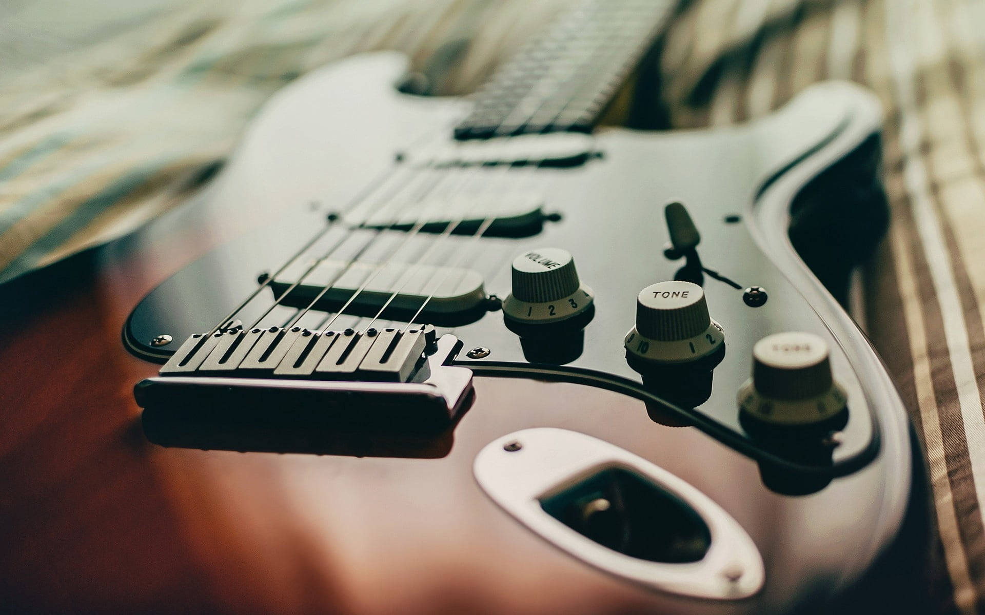 wooden electricity powered guitar, sleek black electric guitar, striped fabric, Full HD Desktop Wallpaper