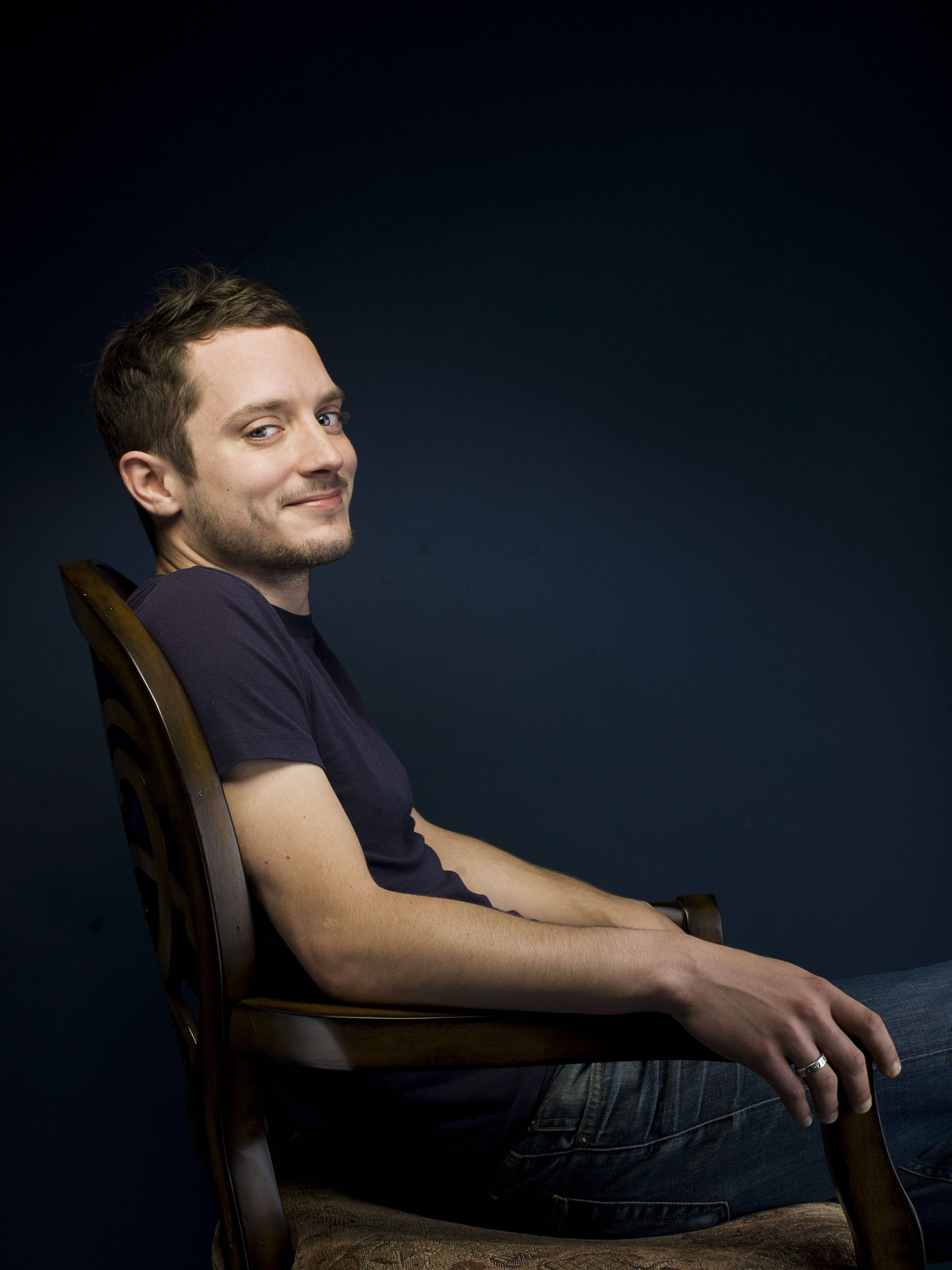Elijah Wood, wooden chair, dark blue studio backdrop, 4K Phone Wallpaper
