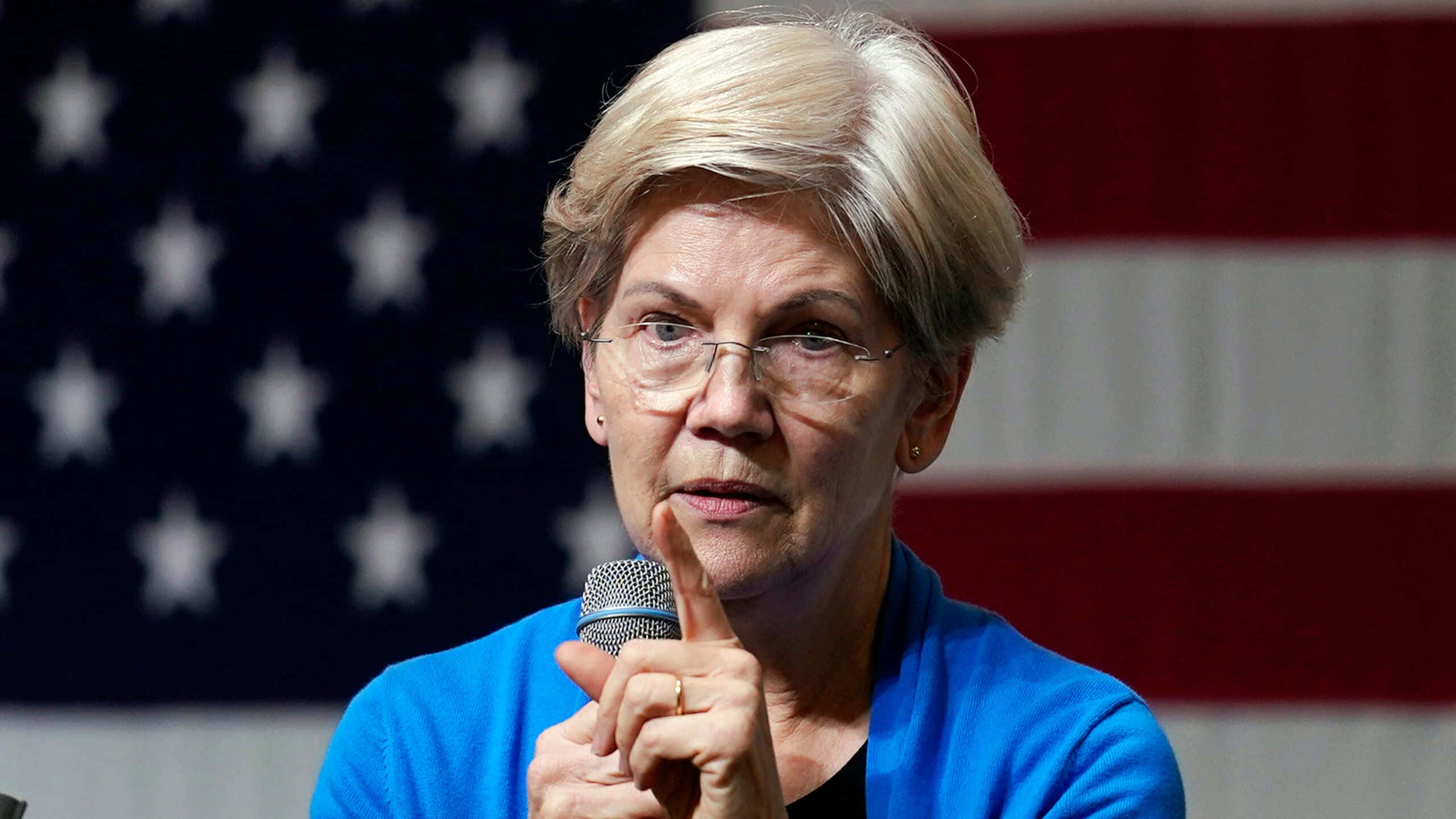 Elizabeth Warren, American flag backdrop, short blonde hair, 2K Desktop Wallpaper