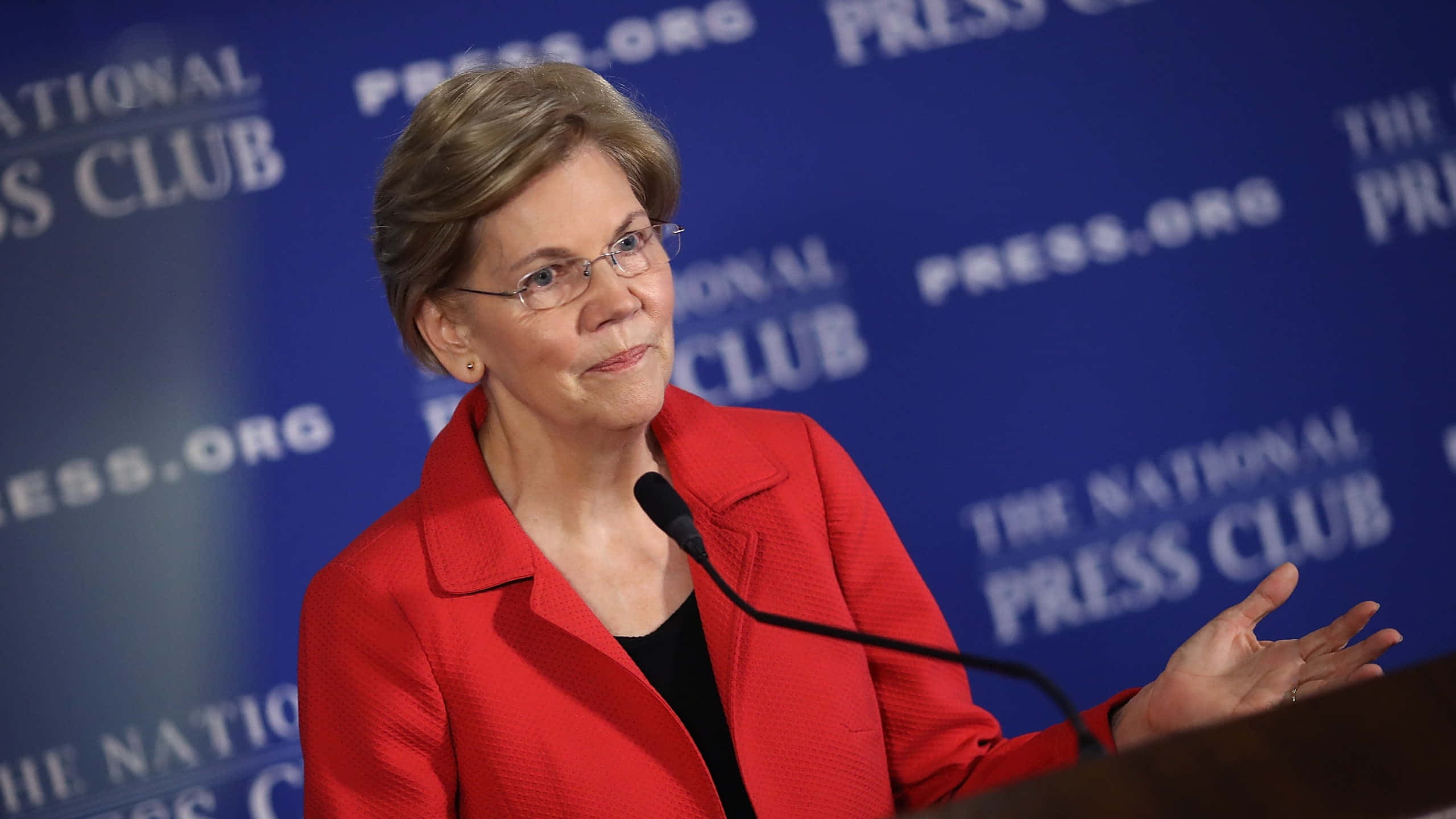 Elizabeth Warren, red blazer, blue press club backdrop, 2K Desktop Wallpaper