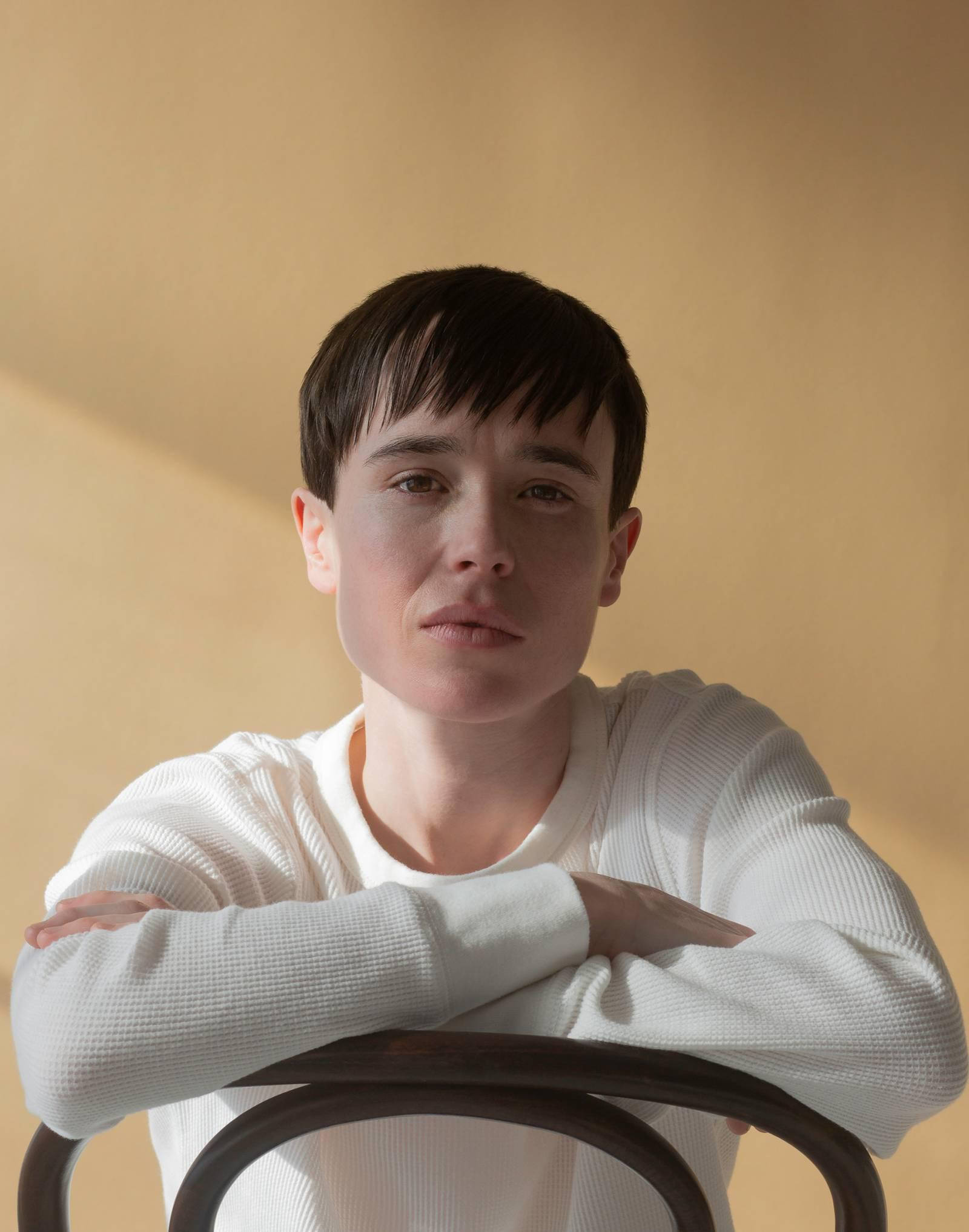 Elliot Page, white ribbed sweater, wooden chair, Full HD Phone Wallpaper