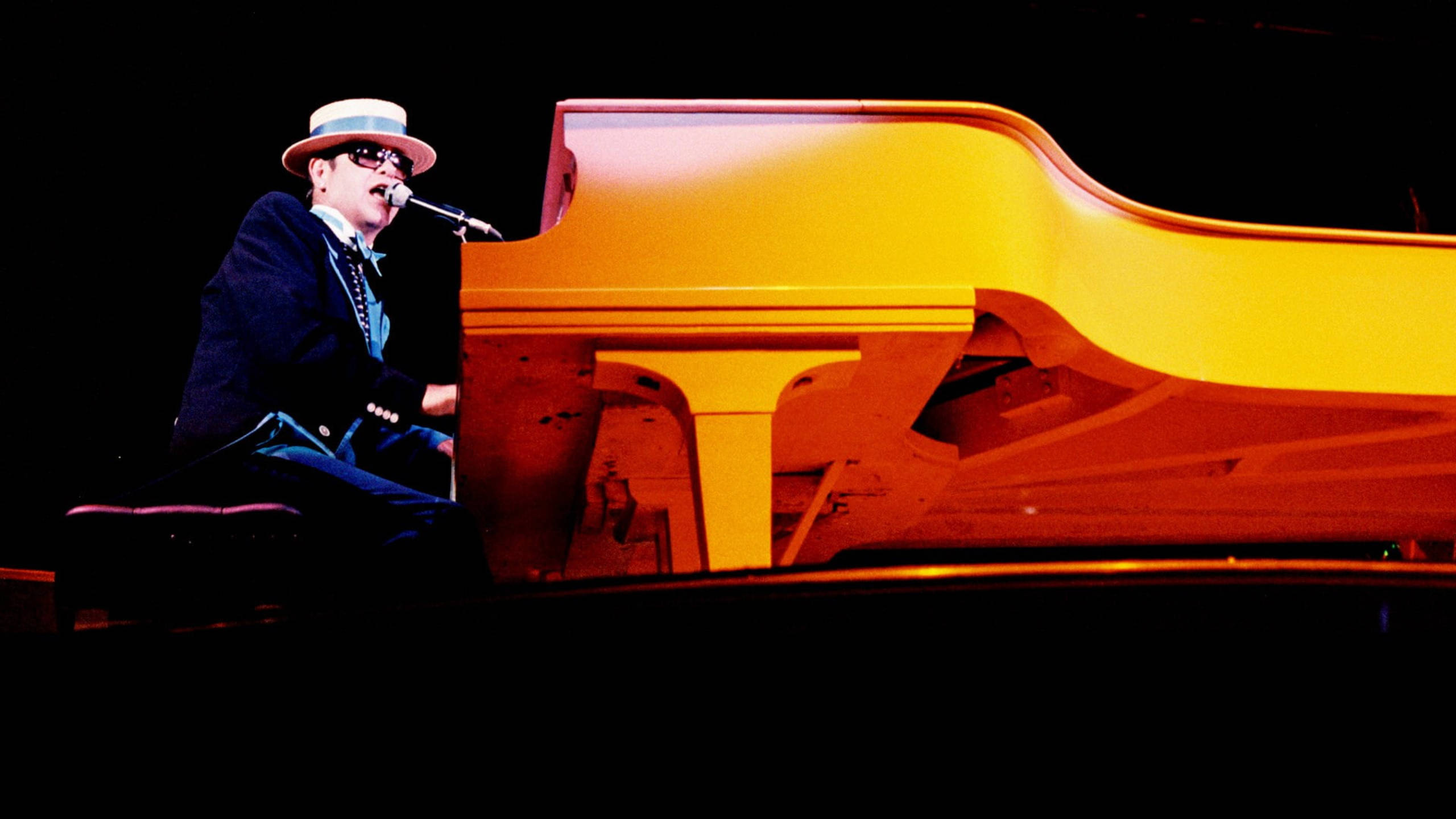 Elton John, gold piano, glowing yellow grand piano, 2K Desktop Wallpaper
